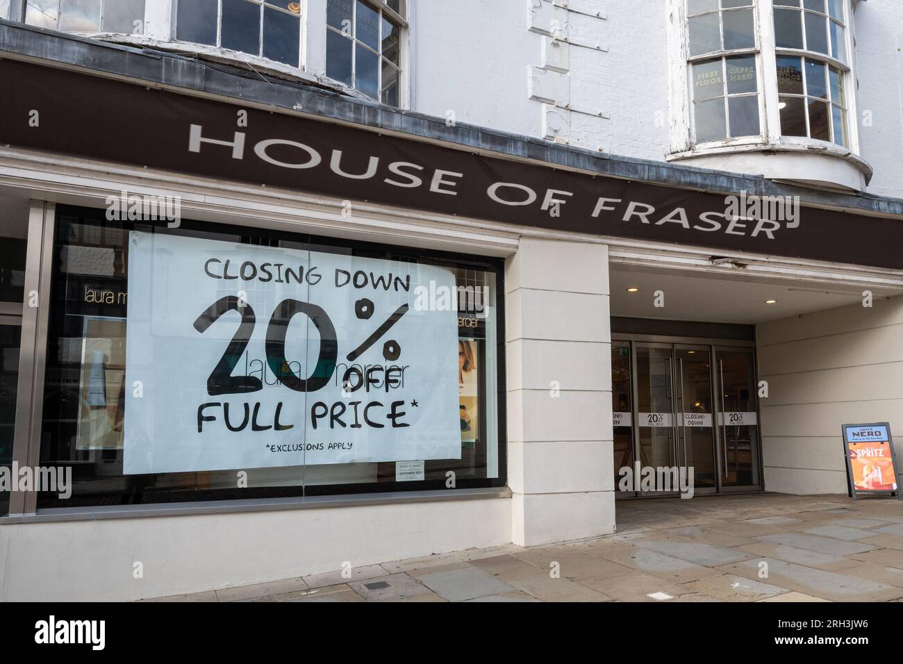 Le grand magasin House of Fraser à Guildford, Surrey, Angleterre, Royaume-Uni, ferme ses portes le 30 septembre 2023. Photographié le 13 août 2023, de grandes affiches dans les vitrines du magasin haut de gamme annoncent une réduction de 20% sur la vente de fermeture. Banque D'Images