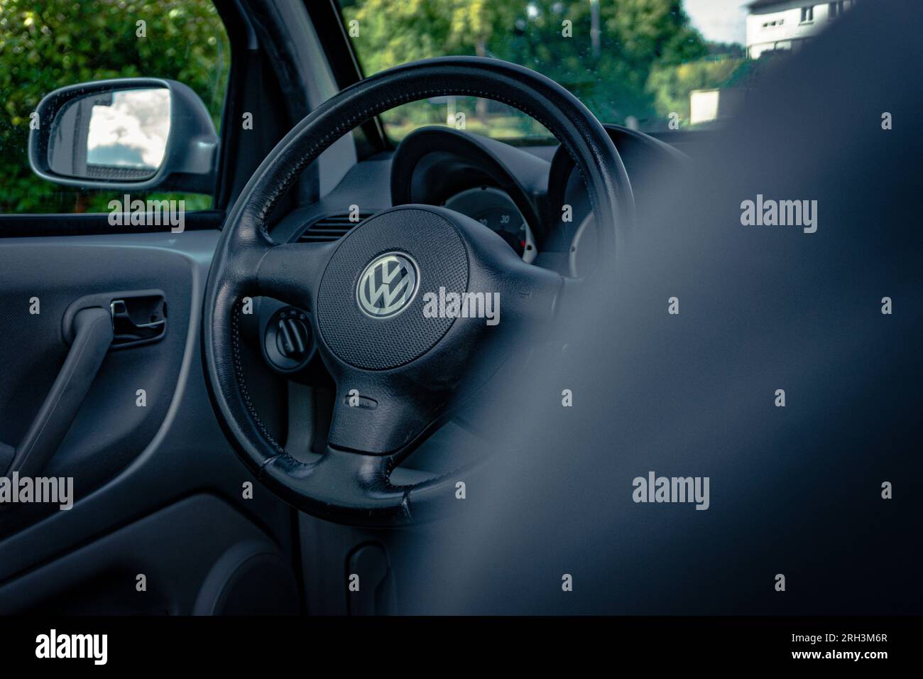 Ingénierie allemande : un intérieur de marque de voiture allemande avec fokus sur le volant en cuir massif au milieu est l'emblème VW Banque D'Images