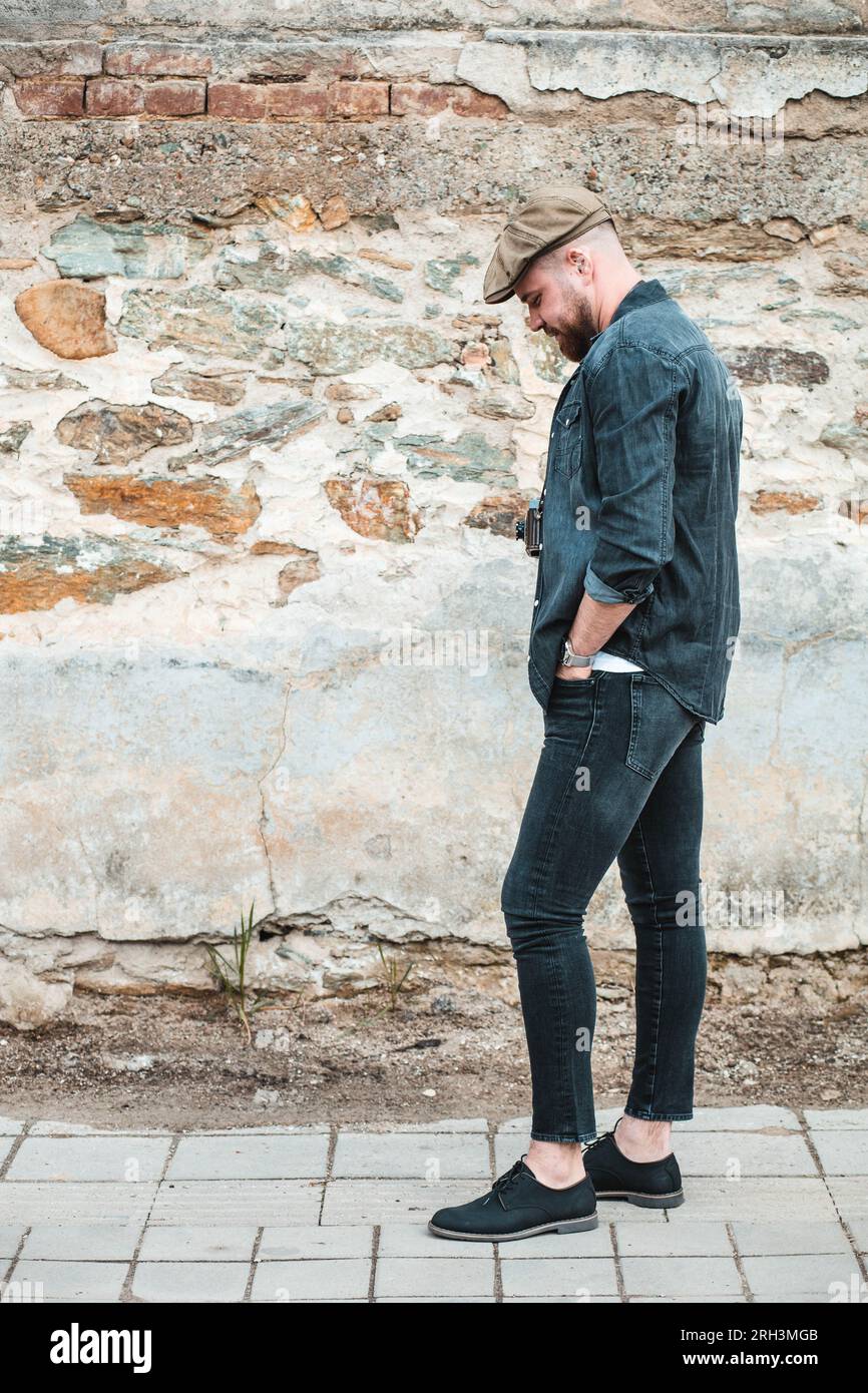 Portrait latéral d'un beau gars avec chapeau de lierre debout Banque D'Images