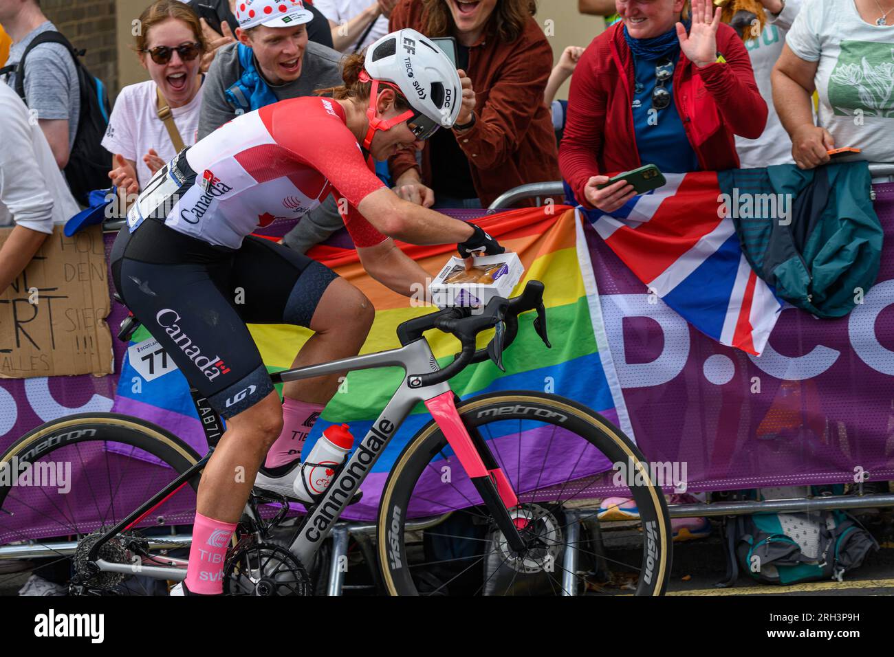 Glasgow, Écosse. 13 août 2023. Une concurrente canadienne acceptant une boîte de beignets d'un spectateur pendant la course cycliste Elite UCI Womens Banque D'Images