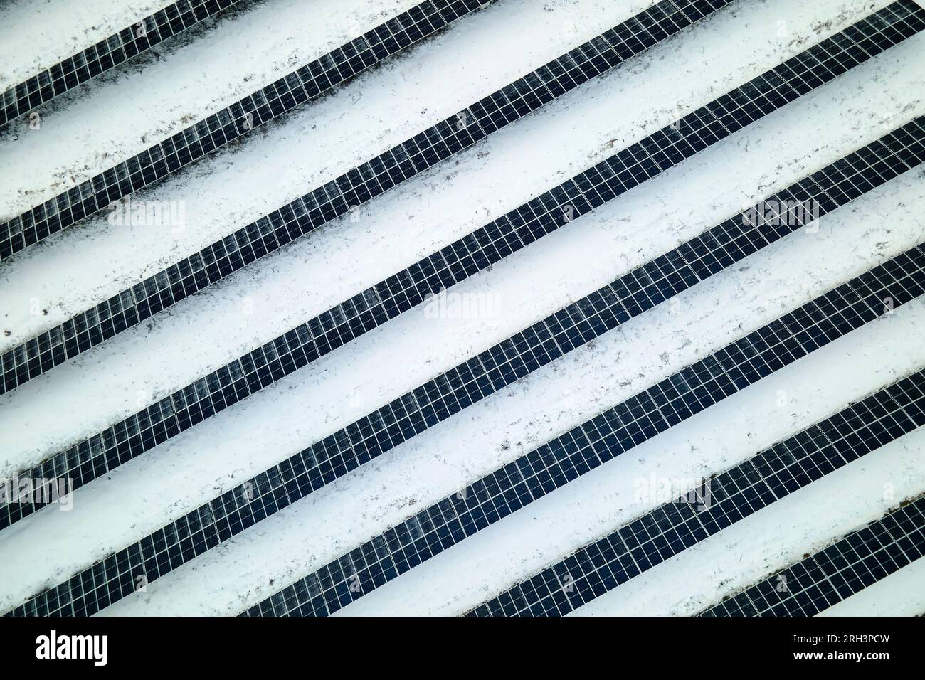 Vue aérienne de la neige couverte centrale électrique durable avec des rangées de panneaux photovoltaïques solaires pour produire de l'énergie électrique propre. Faible Banque D'Images