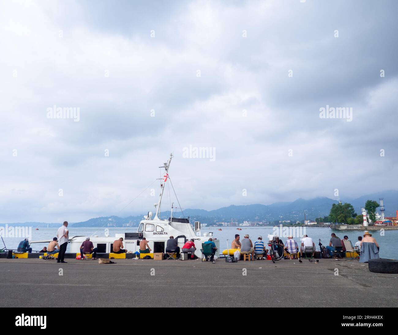 Batumi, Géorgie. 08.13.2023 pêcheurs près des navires. Les gens à la jetée. Passe-temps préféré. Pêche au port. Nourriture familiale. les gens avec des cannes à pêche Banque D'Images