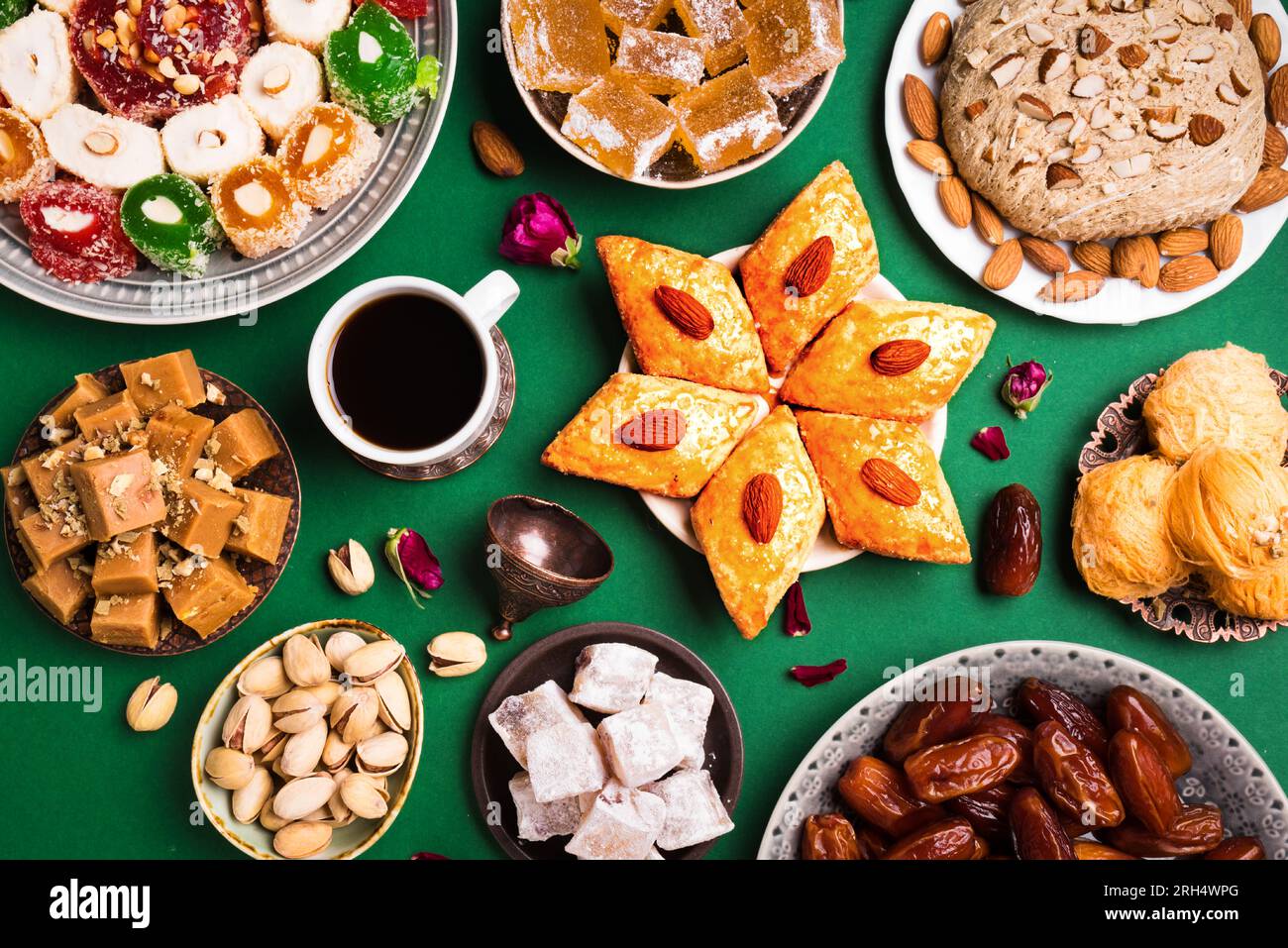 Sucreries du Moyen-Orient, délices turcs et café noir sur fond vert. Assortiment de desserts arabes, rahat lokum, halva, sherber, pismaniye avec noix Banque D'Images