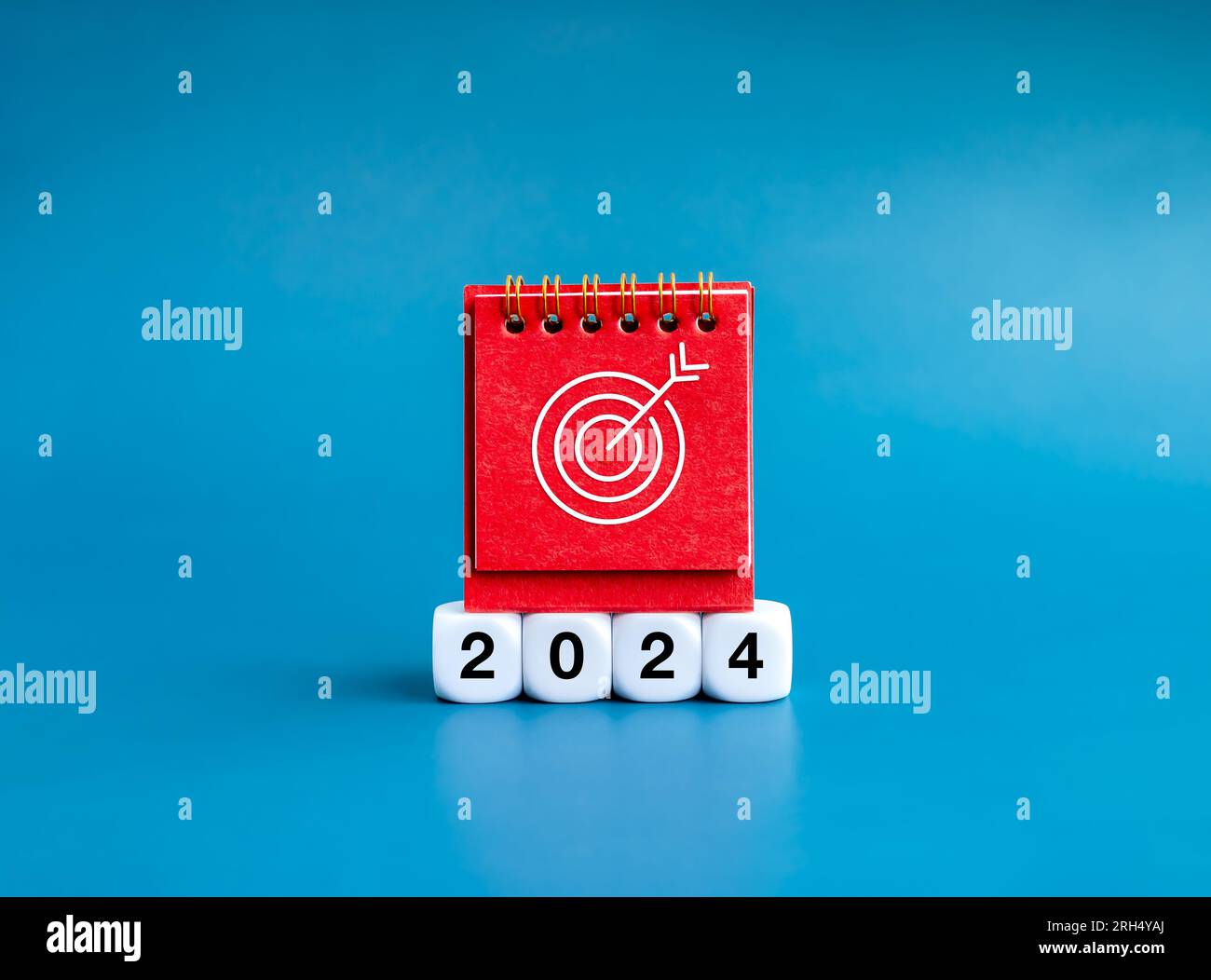 Bonne année 2024 avec le concept de fond de bannière de plan d'action d'objectifs. Icône Target sur la couverture rouge du calendrier de bureau debout sur des blocs blancs avec n de 2024 ans Banque D'Images