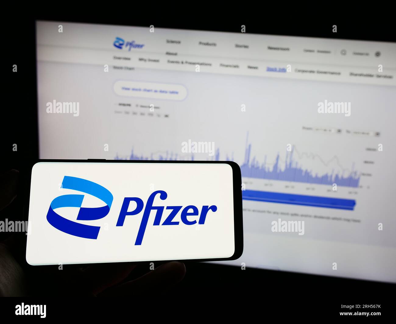 Personne tenant un téléphone mobile avec le logo de la société pharmaceutique américaine Pfizer Inc. Sur l'écran devant la page Web. Concentrez-vous sur l'affichage du téléphone. Banque D'Images