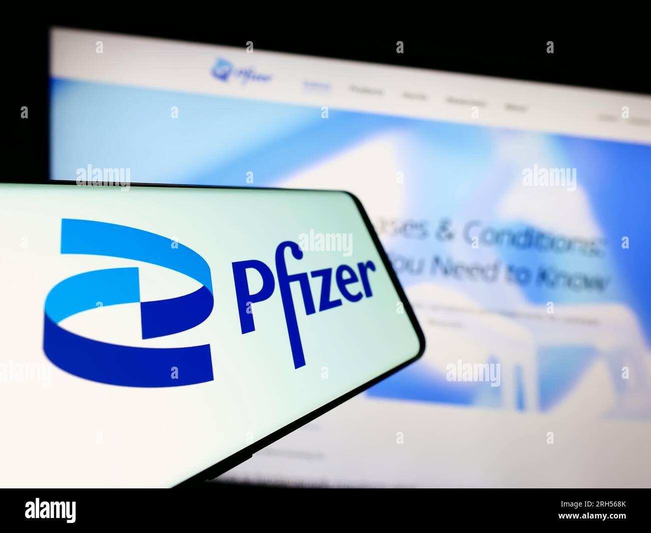 Téléphone portable avec le logo de la société pharmaceutique américaine Pfizer Inc. Sur l'écran devant le site Web de l'entreprise. Concentrez-vous sur le centre gauche de l'écran du téléphone. Banque D'Images