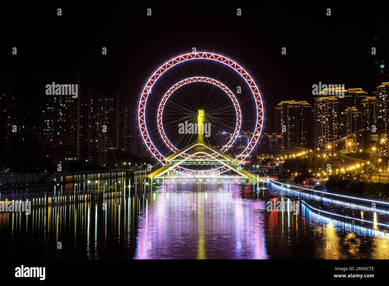 Double exposition du Tianjin Eye, Chine. Ville brouillant les lumières, paysage urbain la nuit fond abstrait. Banque D'Images