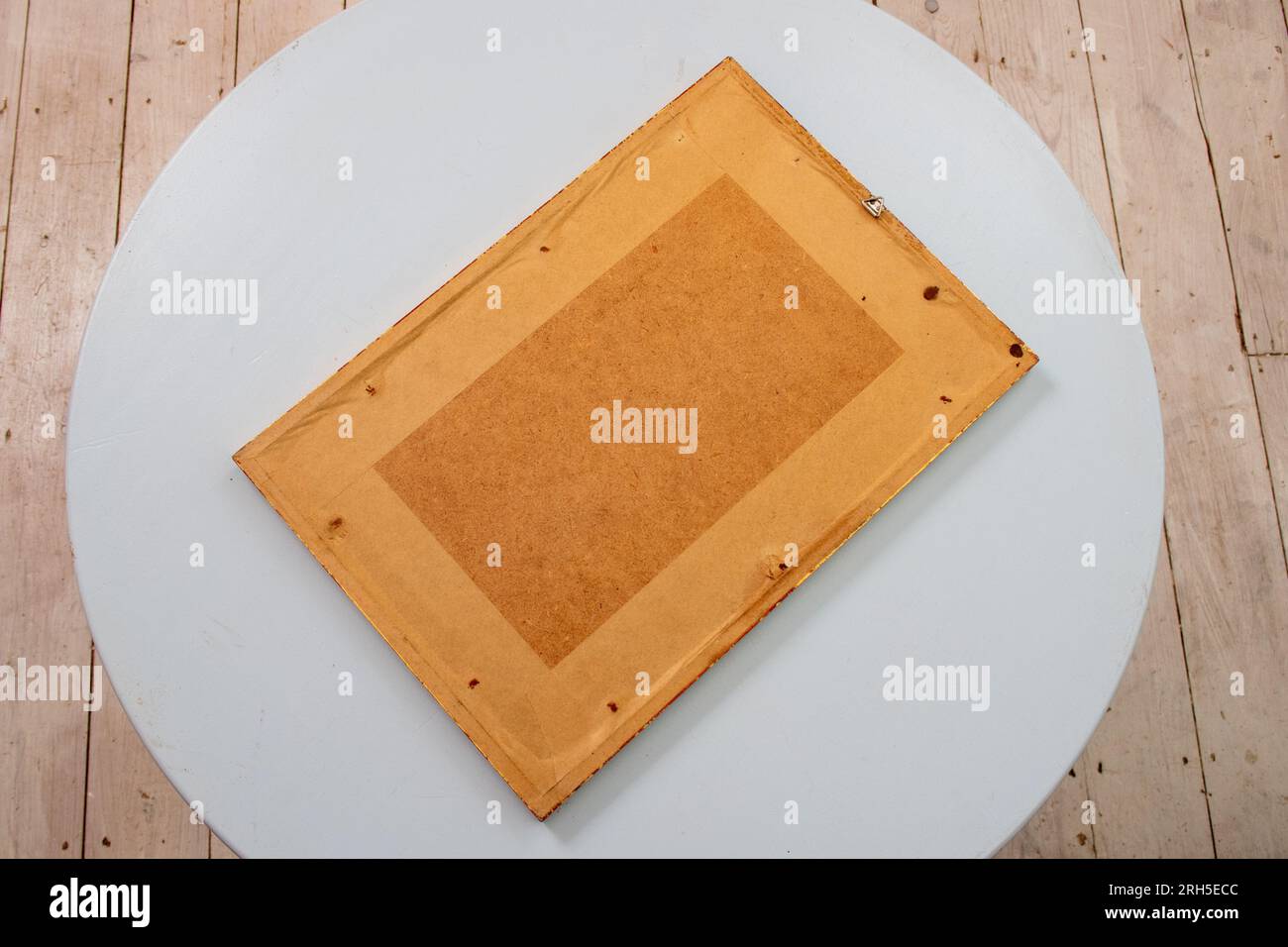 Le dos rectangulaire d'une impression fremd sur une table circulaire bleu pâle fait une composition abstraite de formes simples contre des planchers lavés blancs Banque D'Images