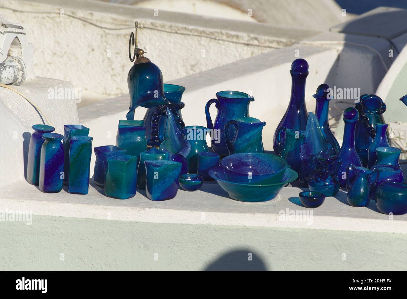 Une collection de poteries bleues exposée avec un vendeur de rue à Oia, sur l'île grecque de Santorin. Banque D'Images