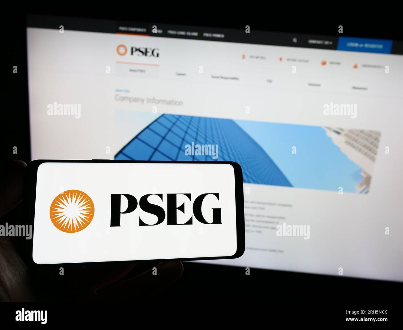 Personne détenant un smartphone avec le logo de la société public Service Enterprise Group (PSEG) sur l'écran devant le site Web. Concentrez-vous sur l'affichage du téléphone. Banque D'Images