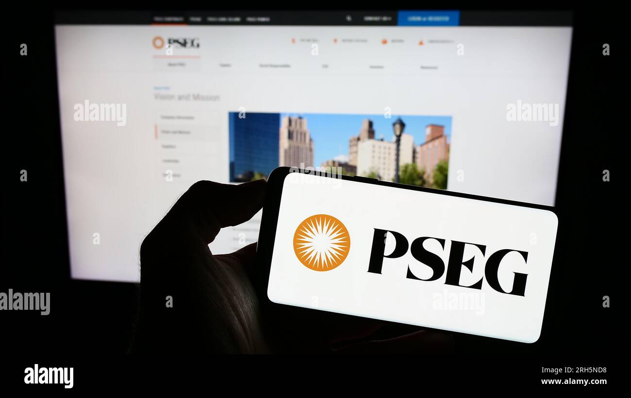Personne détenant un téléphone portable avec le logo de la société public Service Enterprise Group (PSEG) sur l'écran devant la page Web. Concentrez-vous sur l'affichage du téléphone. Banque D'Images