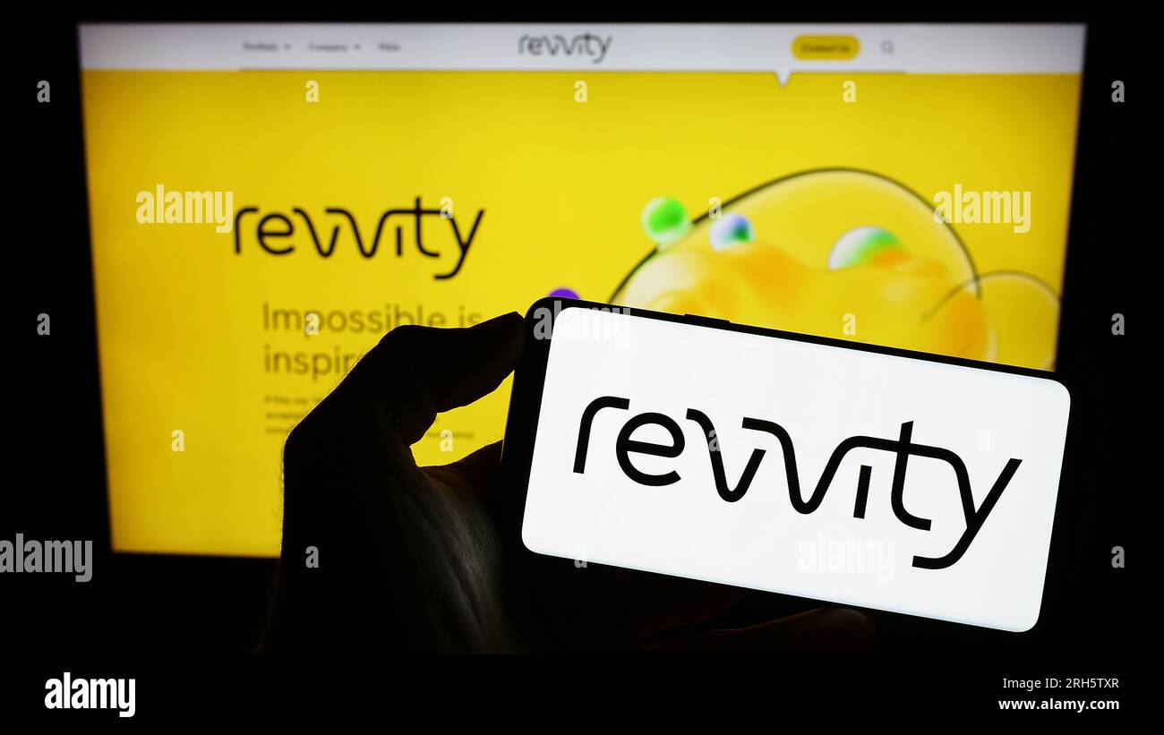 Personne détenant un smartphone avec le logo de la société américaine de sciences de la vie Revvity Inc. Sur l'écran devant le site Web. Concentrez-vous sur l'affichage du téléphone. Banque D'Images
