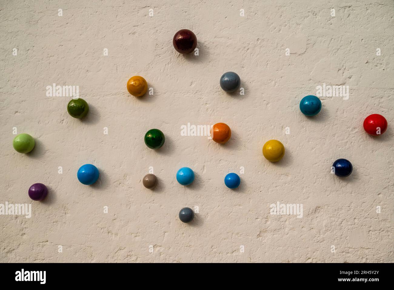 Divers marbres ronds en céramique colorés exposés sur un mur à Grottaglie, Italie Banque D'Images