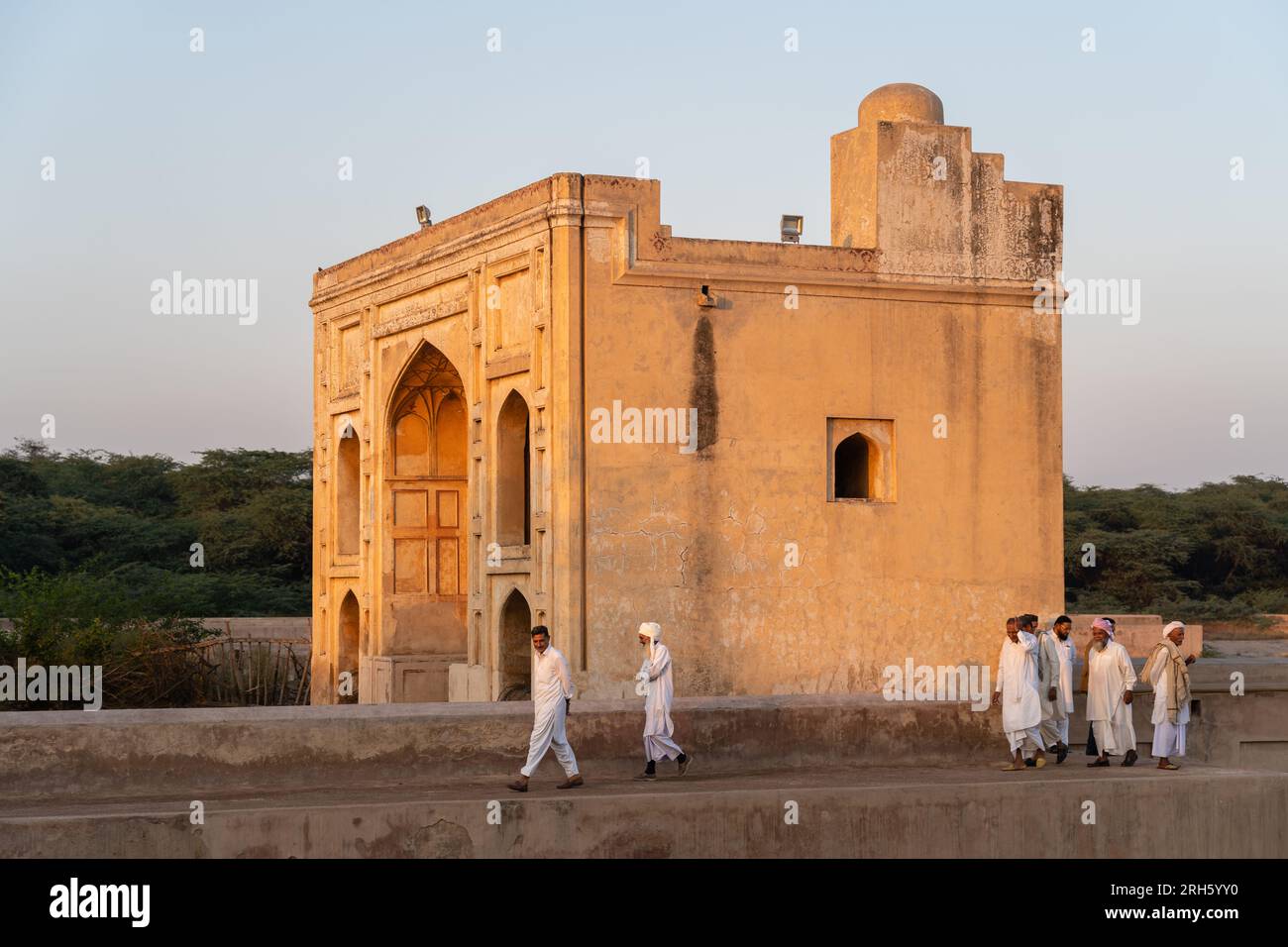 Sheikhupura, Punjab, Pakistan - 11 08 2019 : hommes punjabi en robe traditionnelle blanche marchant au coucher du soleil devant l'ancienne porte Hiran Minar Banque D'Images