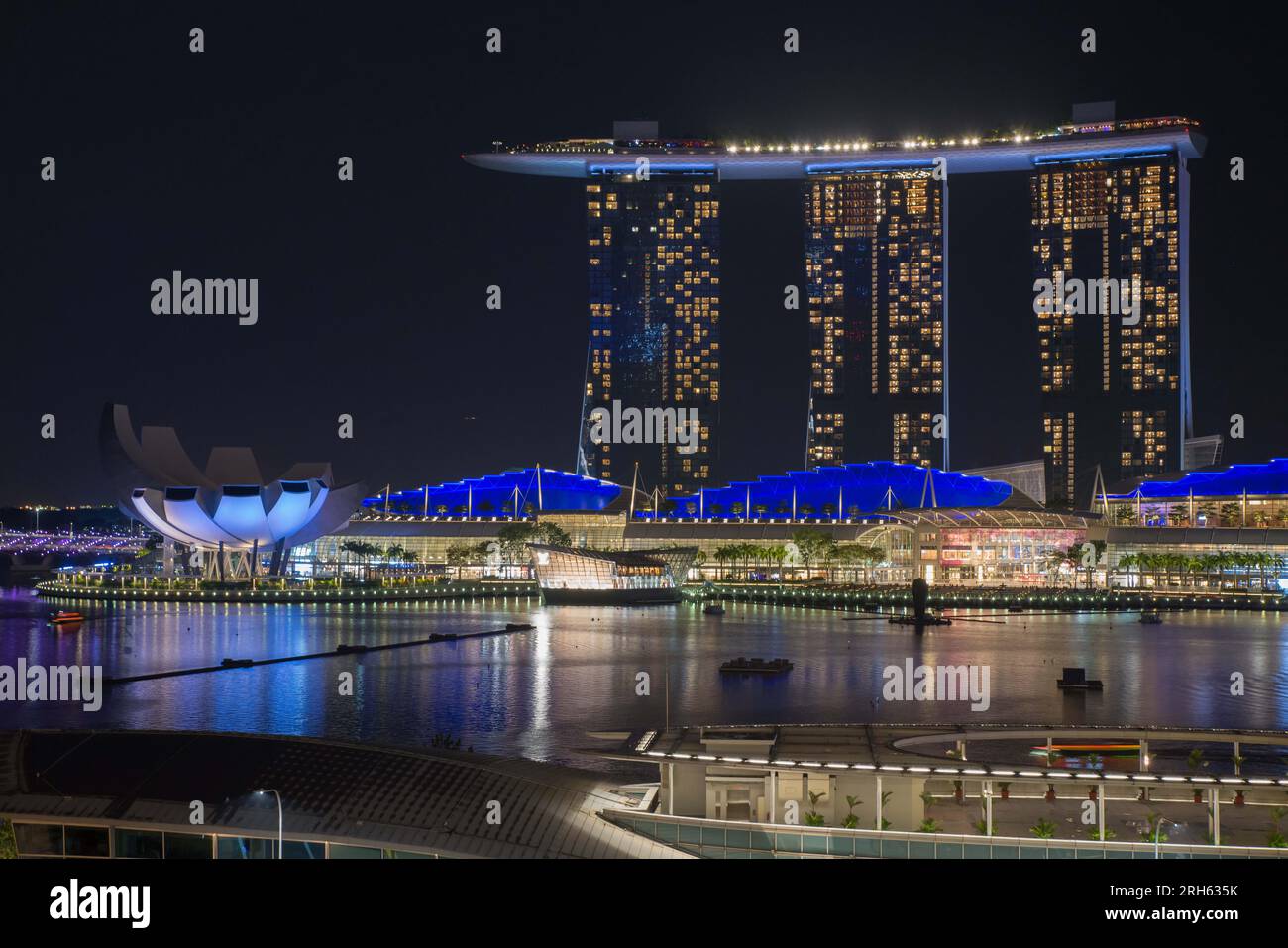 Vue de l'autre côté de la rivière Singapour la nuit vers l'hôtel Marina Bay Sands. Le bâtiment emblématique ArtScience Museum se trouve sur la gauche Banque D'Images