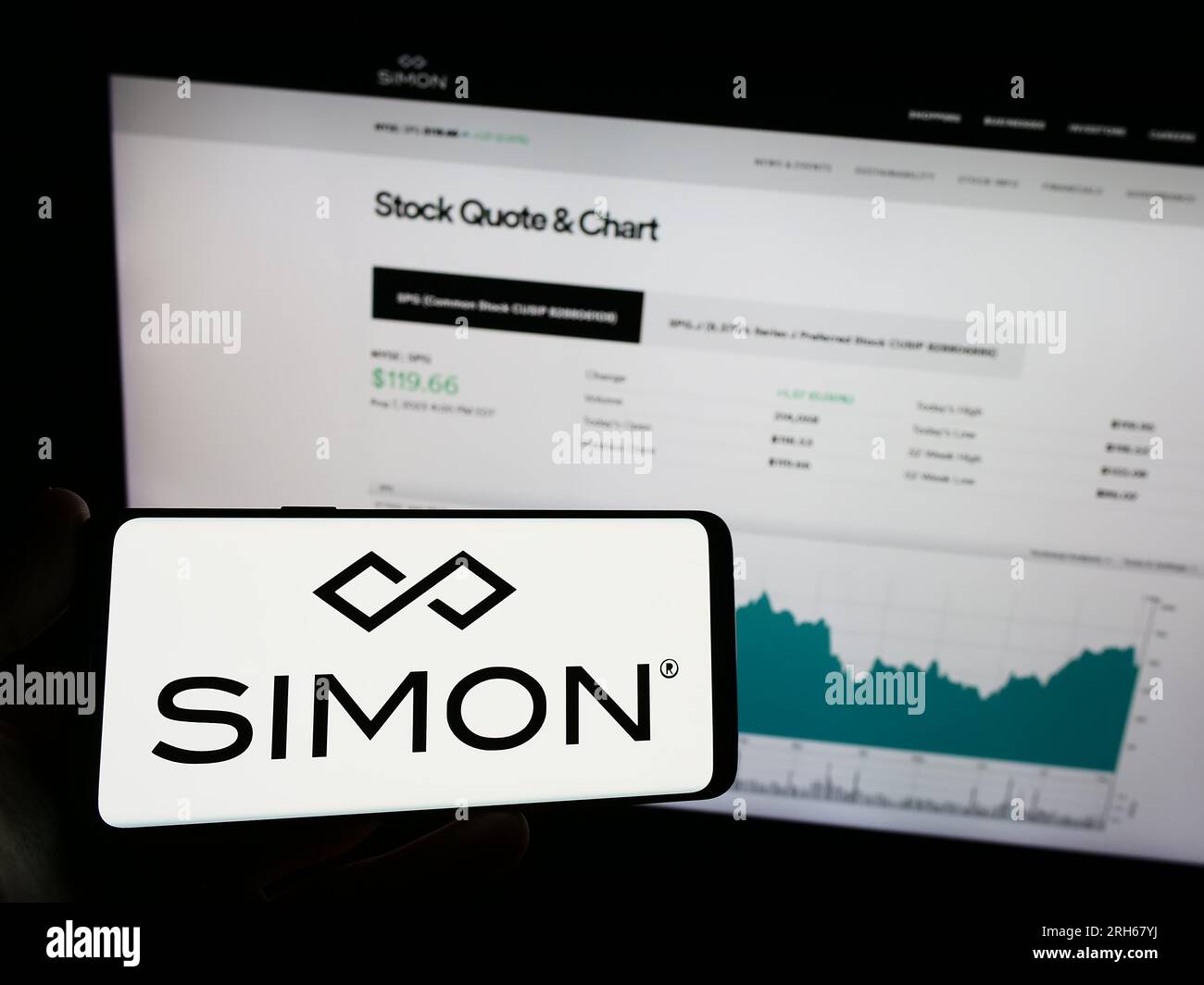 Personne détenant un téléphone mobile avec le logo de la société immobilière américaine Simon Property Group Inc. Sur l'écran devant la page Web. Concentrez-vous sur l'affichage du téléphone. Banque D'Images