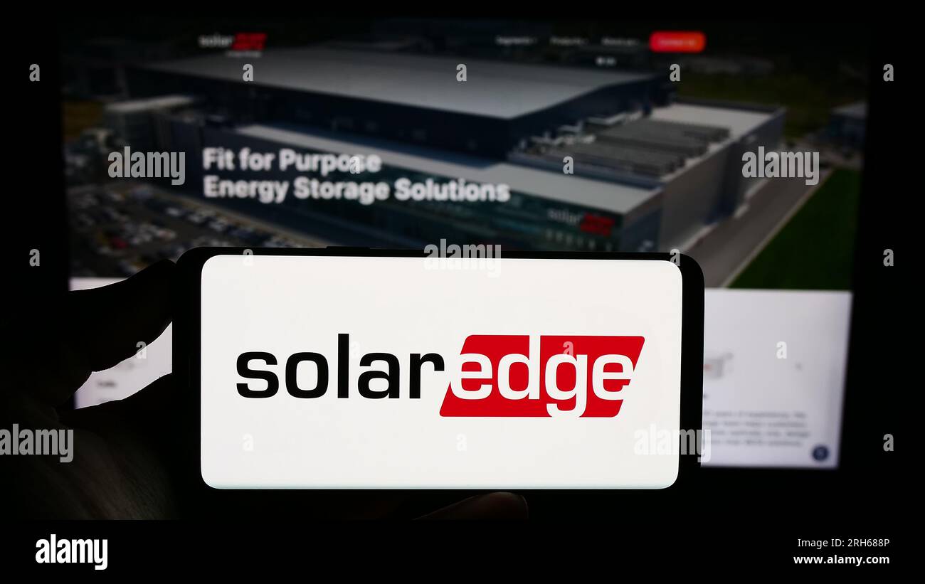 Personne tenant un smartphone avec le logo de la société israélienne SolarEdge technologies Inc. Sur l'écran devant le site Web. Concentrez-vous sur l'affichage du téléphone. Banque D'Images