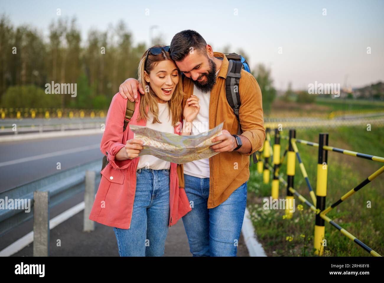Heureux couple souriant regardent la carte dans la ville. Les touristes font du tourisme dans la ville. Banque D'Images