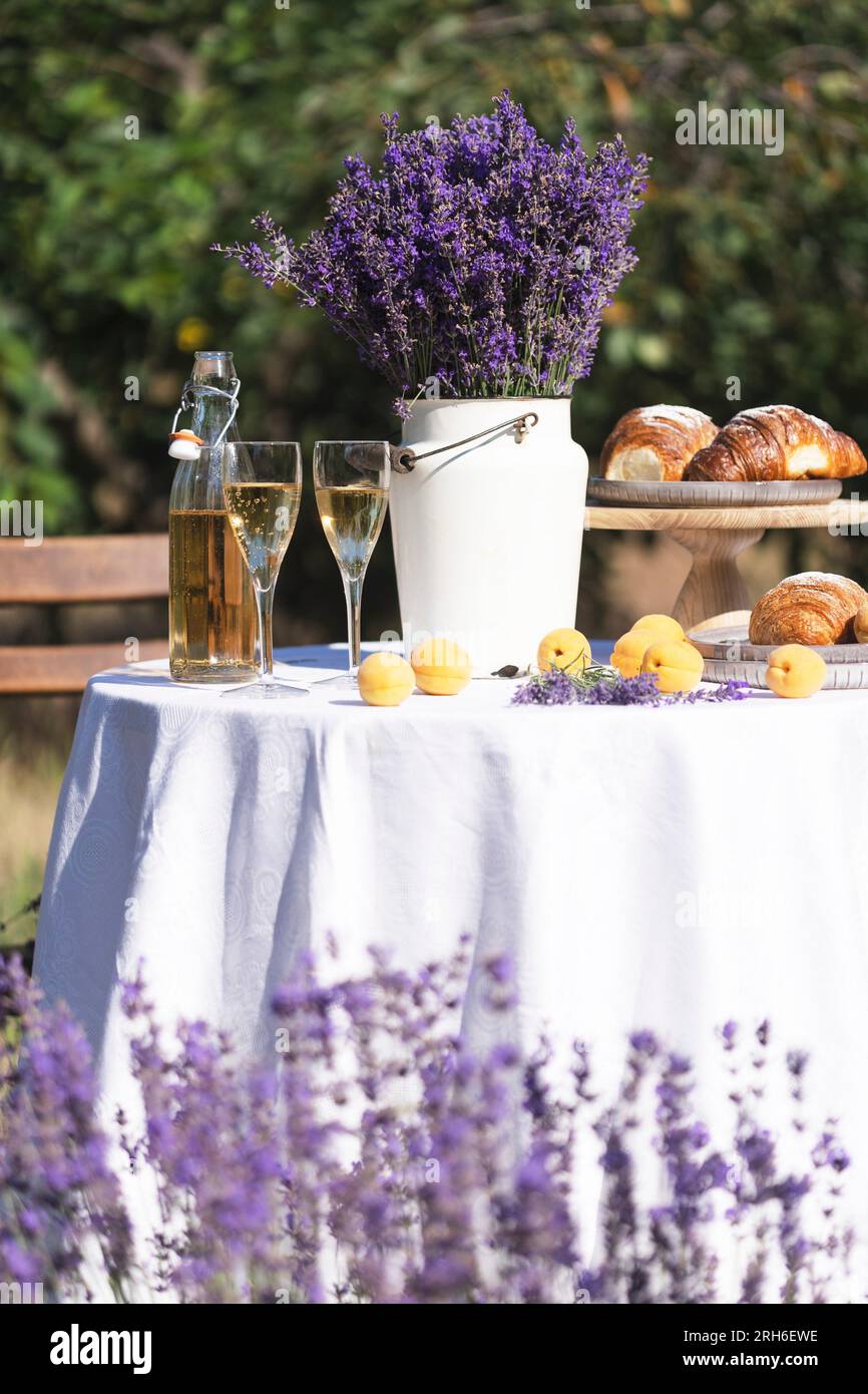 limonade, croissants, abricots et bouquet de lavande sur une table dans le jardin Banque D'Images