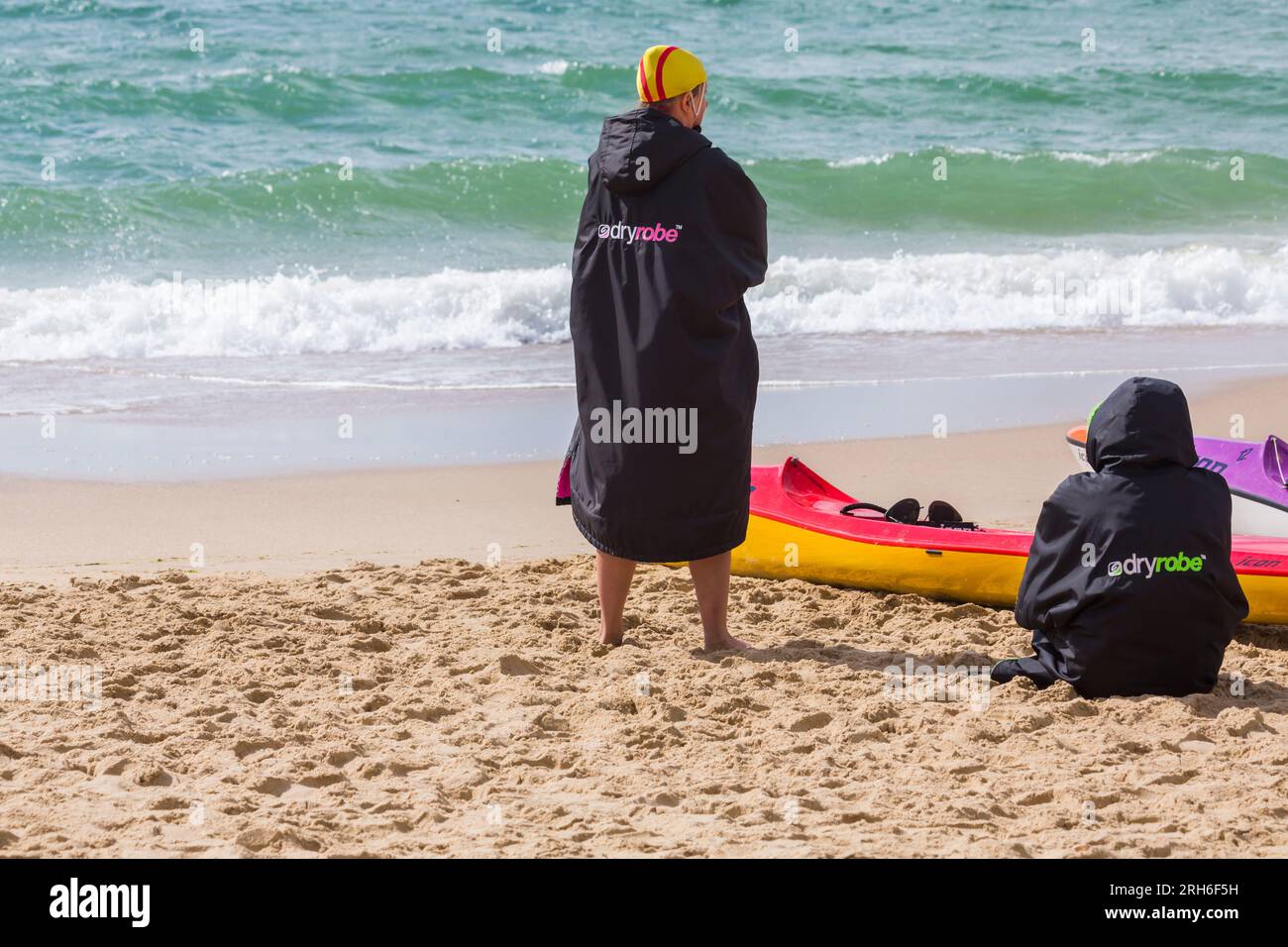 Femmes portant Dry Robe pour garder au chaud à Branksome Chine Beach, Poole, Dorset, Royaume-Uni en août Banque D'Images