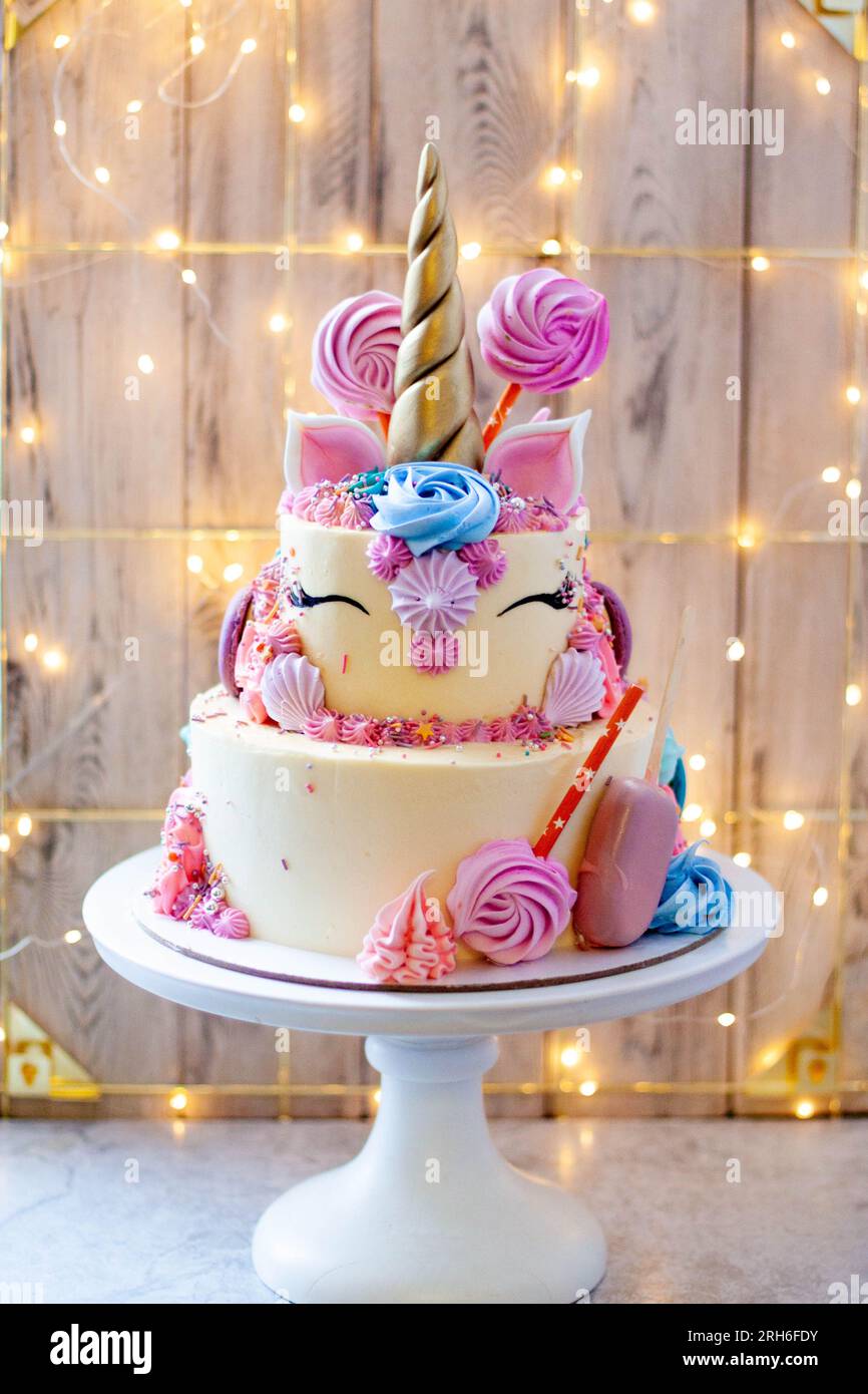 Gâteau licorne d'anniversaire à deux couches avec corne fondante dorée,  cils et glaçage au fromage à la crème sur fond de bokeh de noël festif  Photo Stock - Alamy