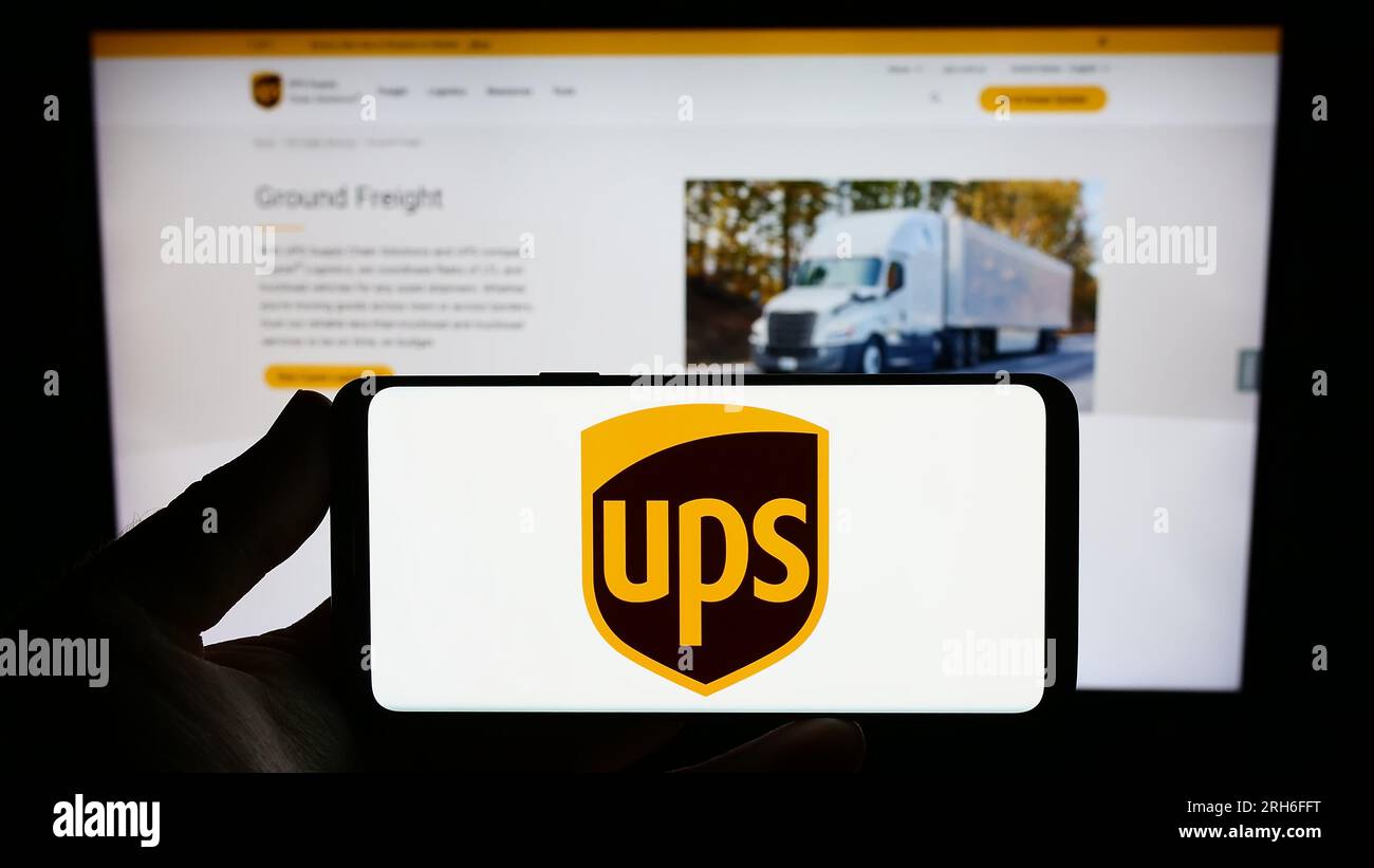 Personne détenant un smartphone avec le logo de la société américaine United Parcel Service Inc. (UPS) sur l'écran devant le site Web. Concentrez-vous sur l'affichage du téléphone. Banque D'Images