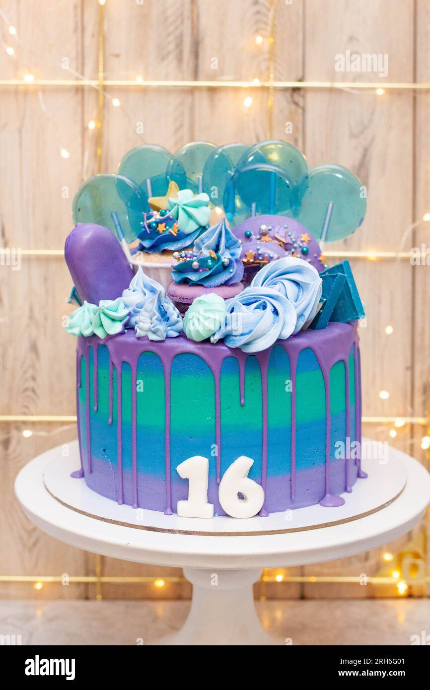 Gâteau d'anniversaire bleu, violet et vert pour un adolescent de seize ans. Sweet seize célébration Banque D'Images