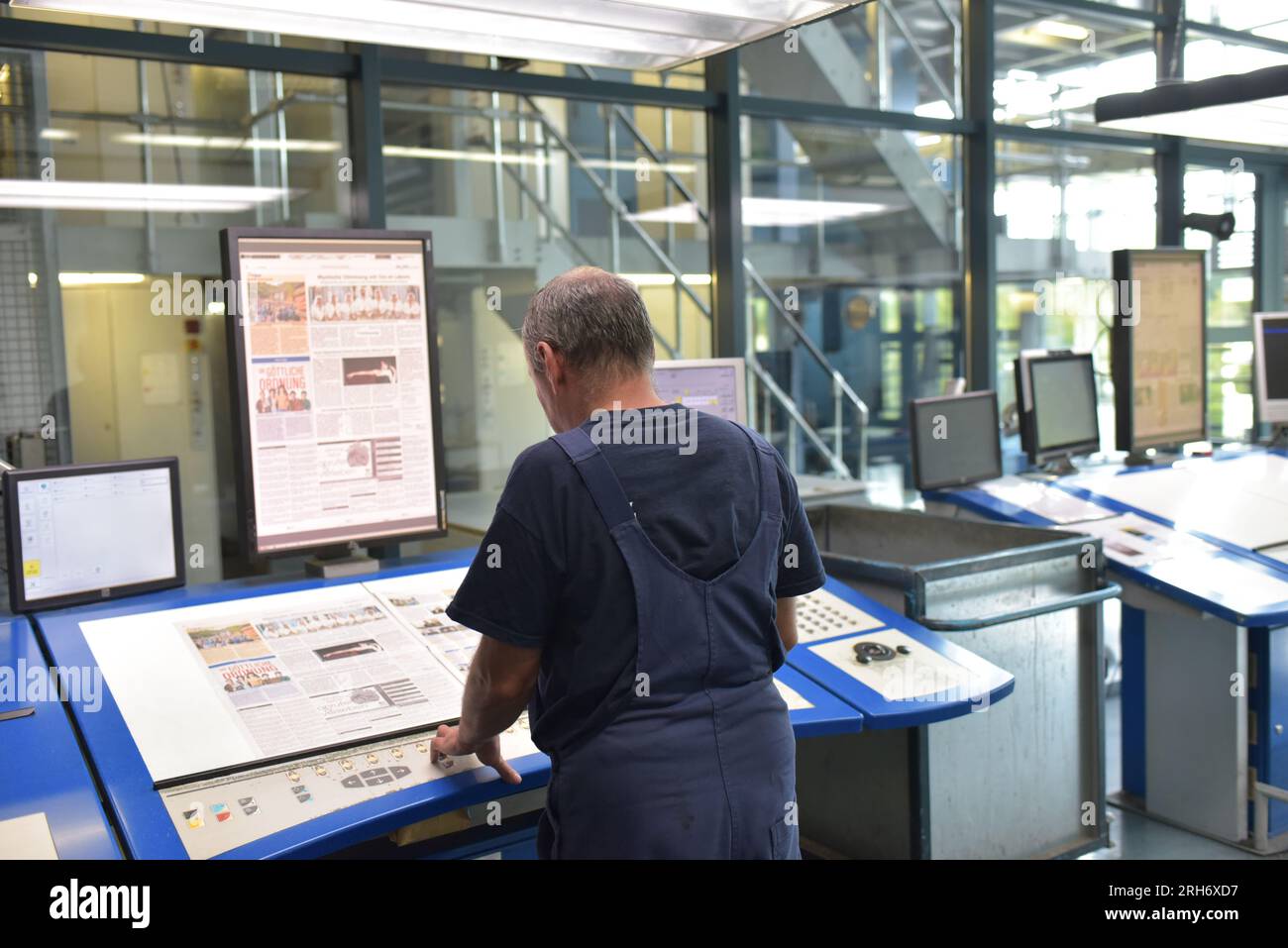 Un travailleur informatique dans une usine d'impression de journaux vérifie la mise en page Banque D'Images