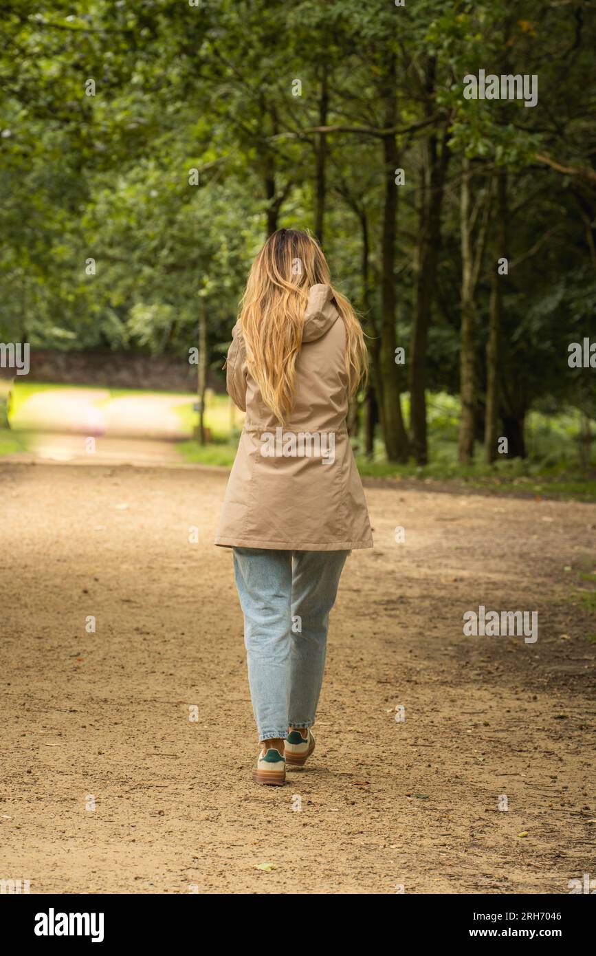 jeune femme marchant à travers la forêt Banque D'Images