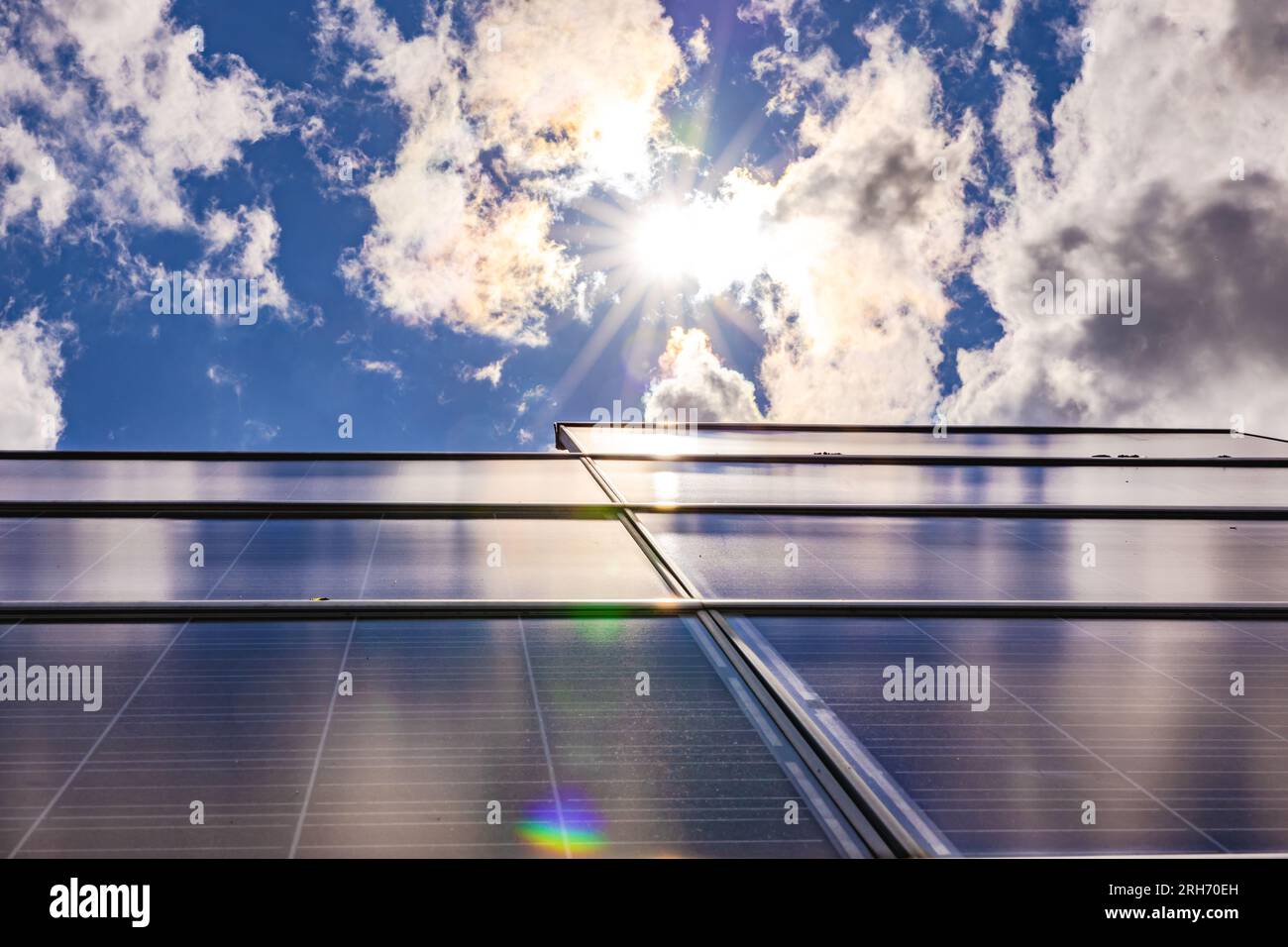 Modules solaires d'un système photovoltaïque sur un toit privé rétroéclairé avec soleil, nuages et étoile solaire, Allemagne Banque D'Images Modules solaires d'un système photovoltaïque sur un toit privé rétroéclairé avec soleil, nuages et étoile solaire, Allemagne Banque D'Images
