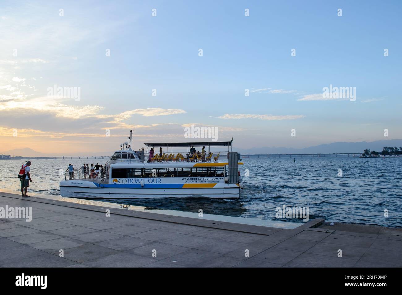 Rio de Janeiro, Brésil, Un bateau nautique ou un engin à passagers quitte le quai au crépuscule. Visites de la baie dans une attraction touristique de la ville Banque D'Images