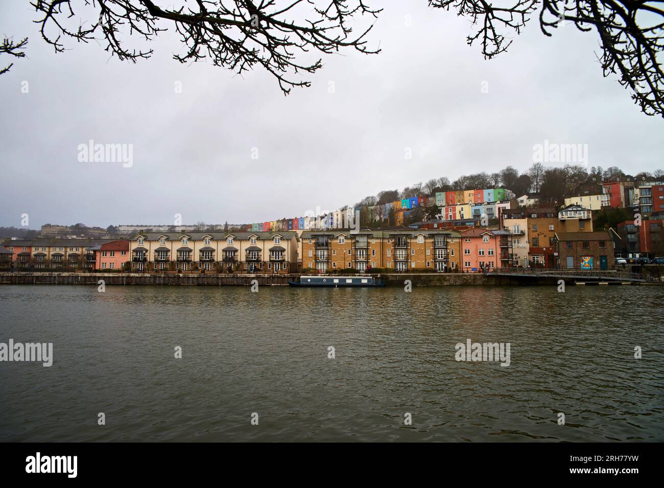 Paysage urbain de Bristol, avec des maisons colorées sur la rivière. Encadrement avec branches. Banque D'Images