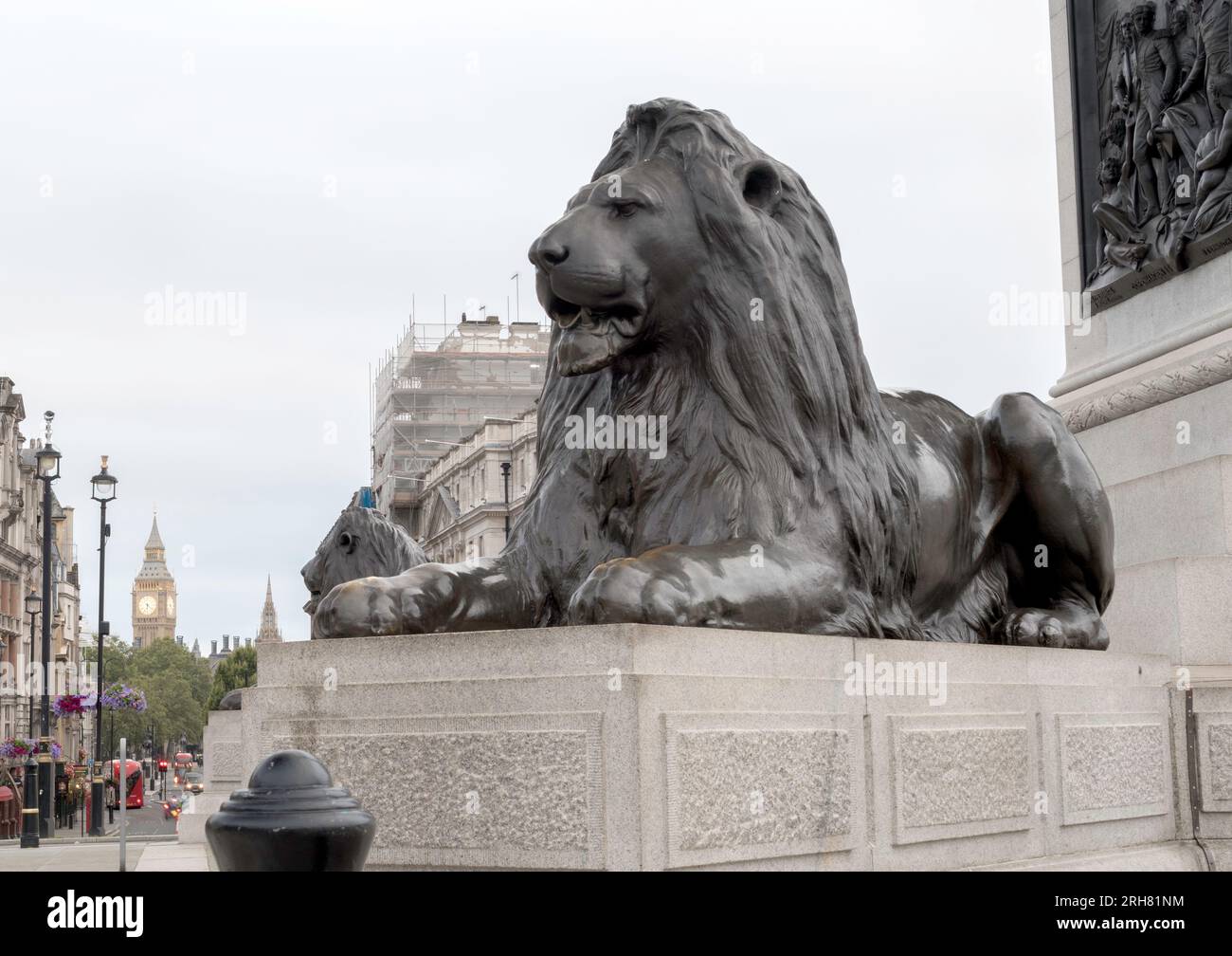 Statue emblématique du lion de Trafalgar Square avec Big Ben en arrière-plan lors d'un concept de jour couvert pour les monuments historiques de Londres, Trafalgar Square Banque D'Images
