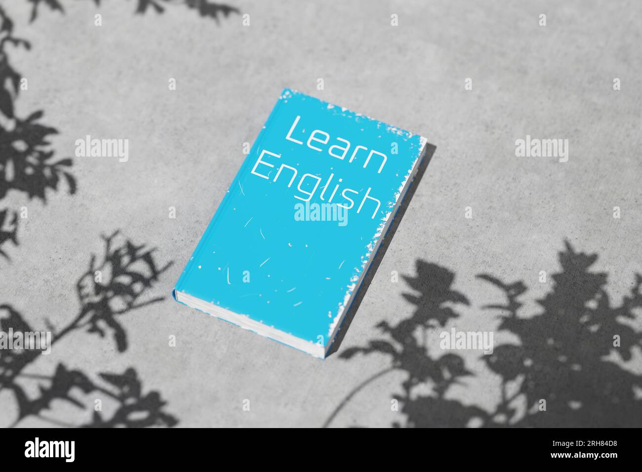 Manuel d'anglais sur une table de ciment par temps clair avec des ombres. Apprentissage de l'anglais. Grammaire anglaise. Apprendre le livre anglais pour l'apprentissage des langues. Banque D'Images