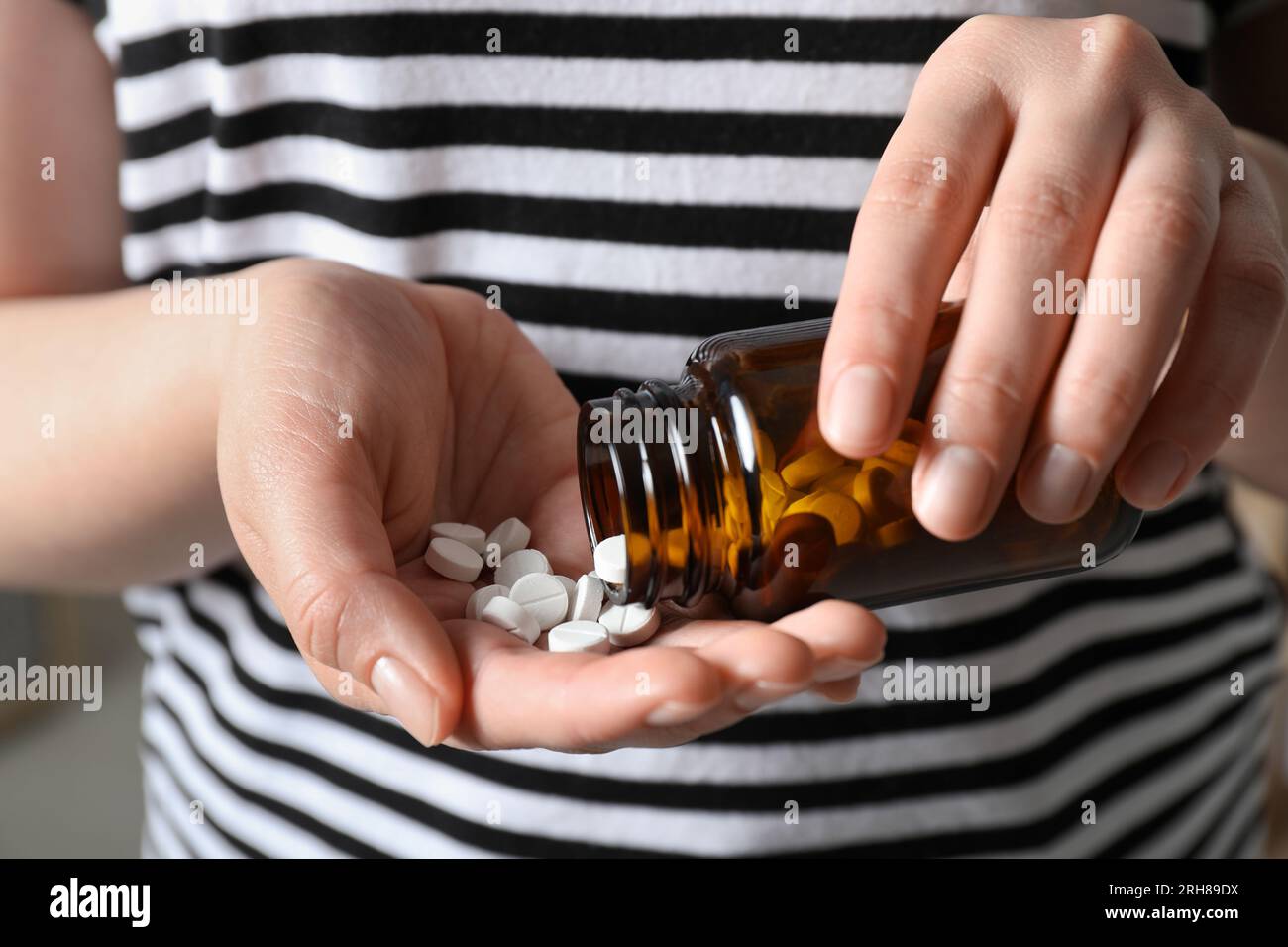 Femme versant des pilules de la bouteille, vue rapprochée Banque D'Images