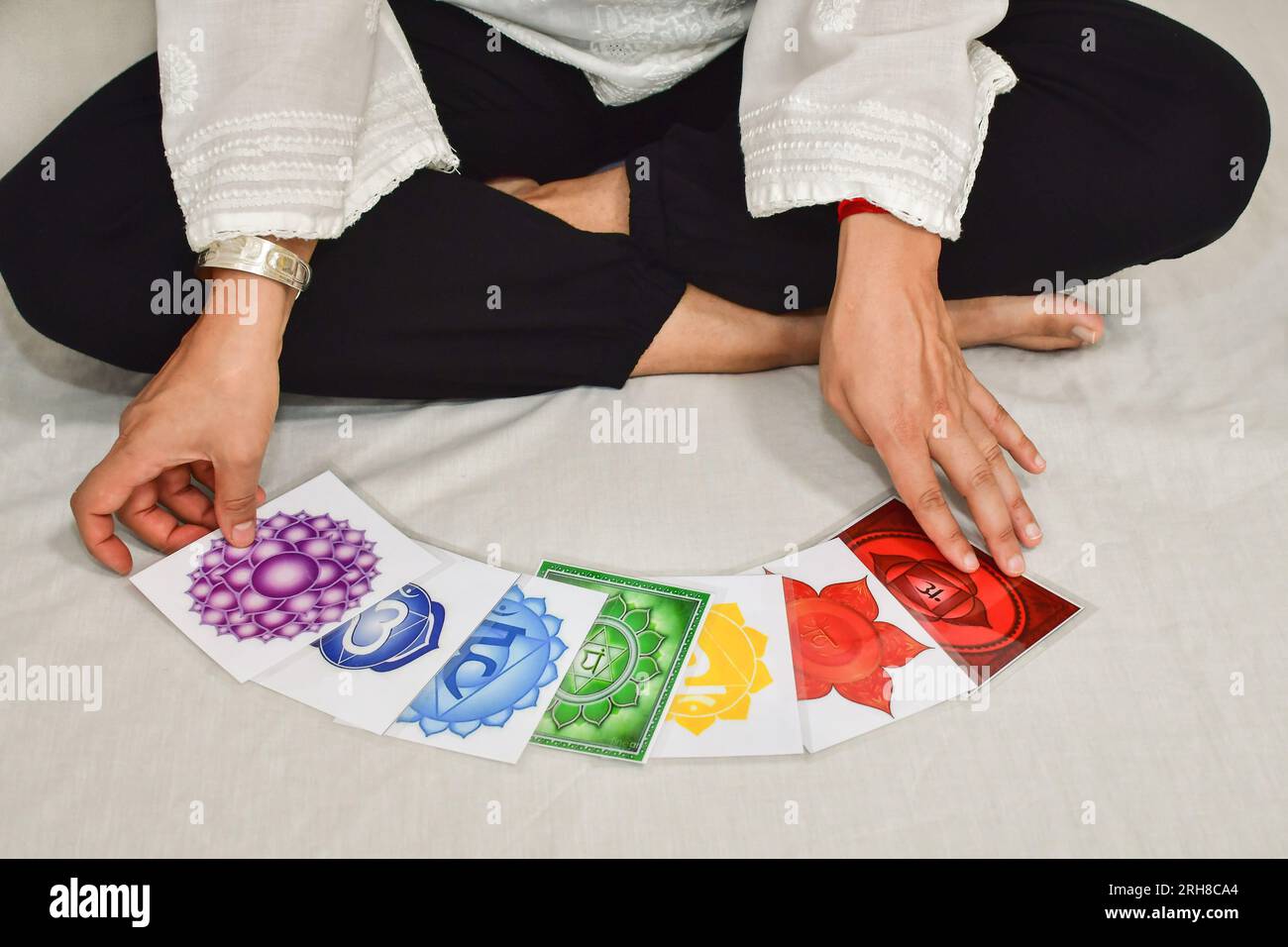 Une femme avec des cartes de chakras pratiquant la méditation. Banque D'Images