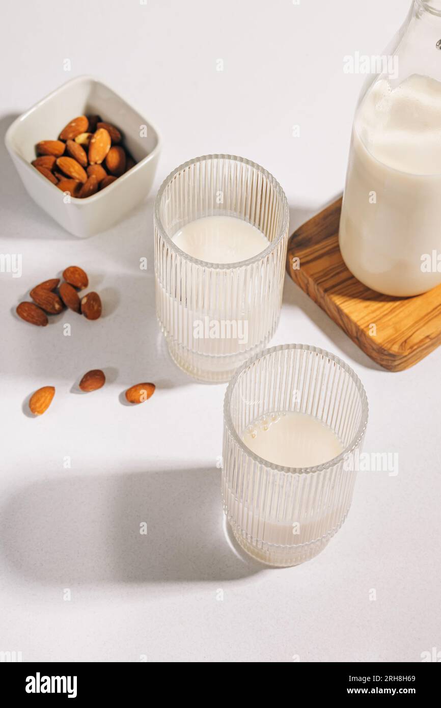 Deux verres côtelés au lait d'amande sur table blanche. Lait végétalien alternatif laitier Banque D'Images