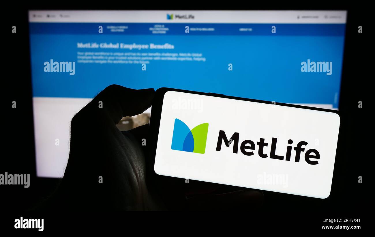 Personne détenant un smartphone avec le logo de la compagnie d'assurance américaine MetLife Inc. Sur l'écran devant le site Web. Concentrez-vous sur l'affichage du téléphone. Banque D'Images