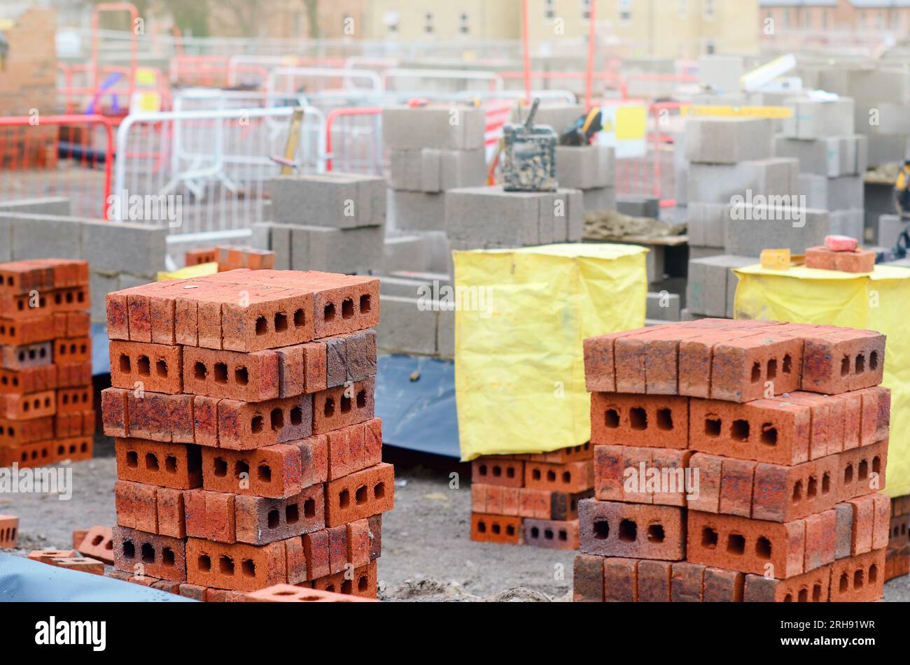 Briques rouges et blocs de béton livrés sur le chantier et placés à côté du lieu de travail prêt pour les briques Banque D'Images