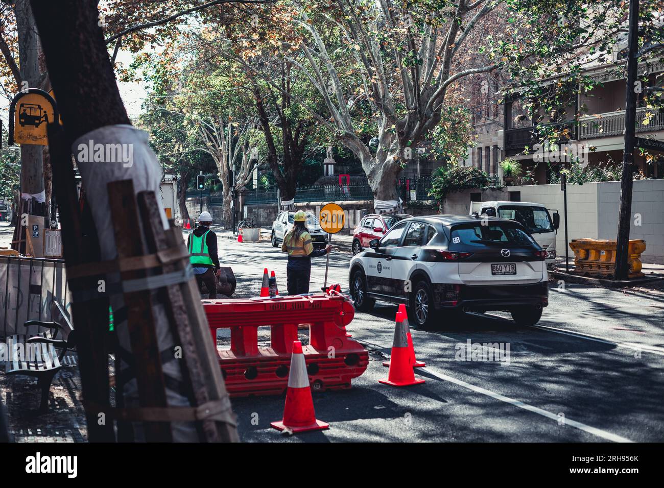 Travaux routiers en cours dans les rues de Sydney. Un homme sucette peut être vu diriger le trafic venant en sens inverse. Banque D'Images