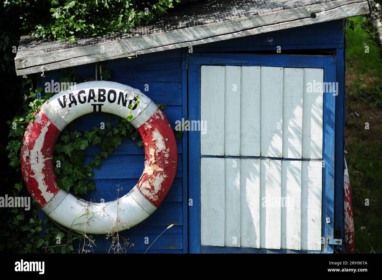 Ancien hangar à bateau rustique, peint en bleu et blanc avec lifebouy Banque D'Images