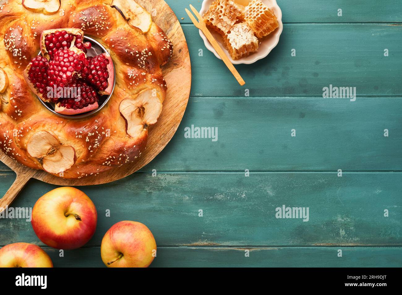 Fêtes juives - Rosh Hashana ou Rosh Hashana. Grenade, pommes, miel et challah rond sur fond de table bleu en bois vieux. Célébrité juive d'automne Banque D'Images