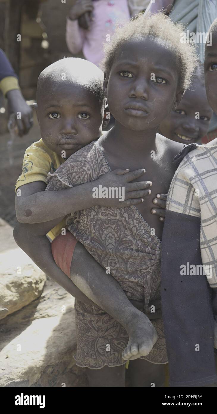 Belle photo d'une sœur africaine tenant son frère cadet sur son dos. ressemblant au sens profond du soin dans notre nature humaine. pauvreté. Banque D'Images