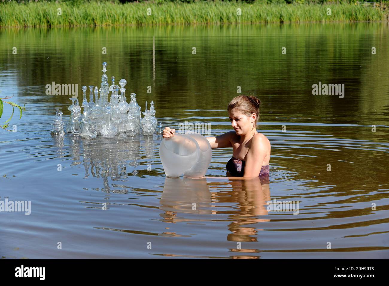 Laura McKinley, artiste verrier basée à Londres, a pu rester cool au travail aujourd'hui en installant sa sculpture en verre dans des eaux froides. Elle est l'une des 15 artistes verriers qui participent à l'exposition Glass Afloat Sculpture Exhibition 2012 qui ouvre la semaine prochaine à l'arboretum Bodenham près de Kidderminster. Banque D'Images