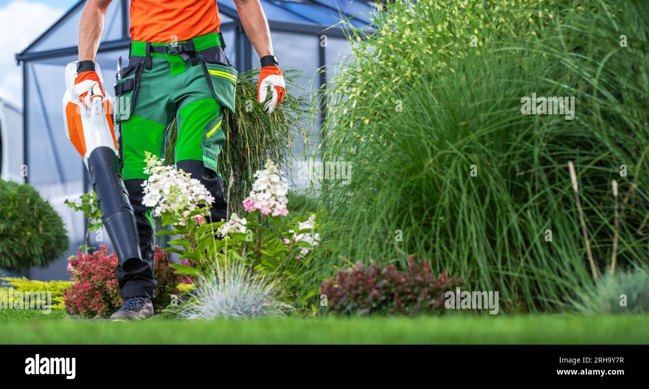 Gardien de jardin avec ventilateur à batterie sans fil nettoyant la cour Banque D'Images