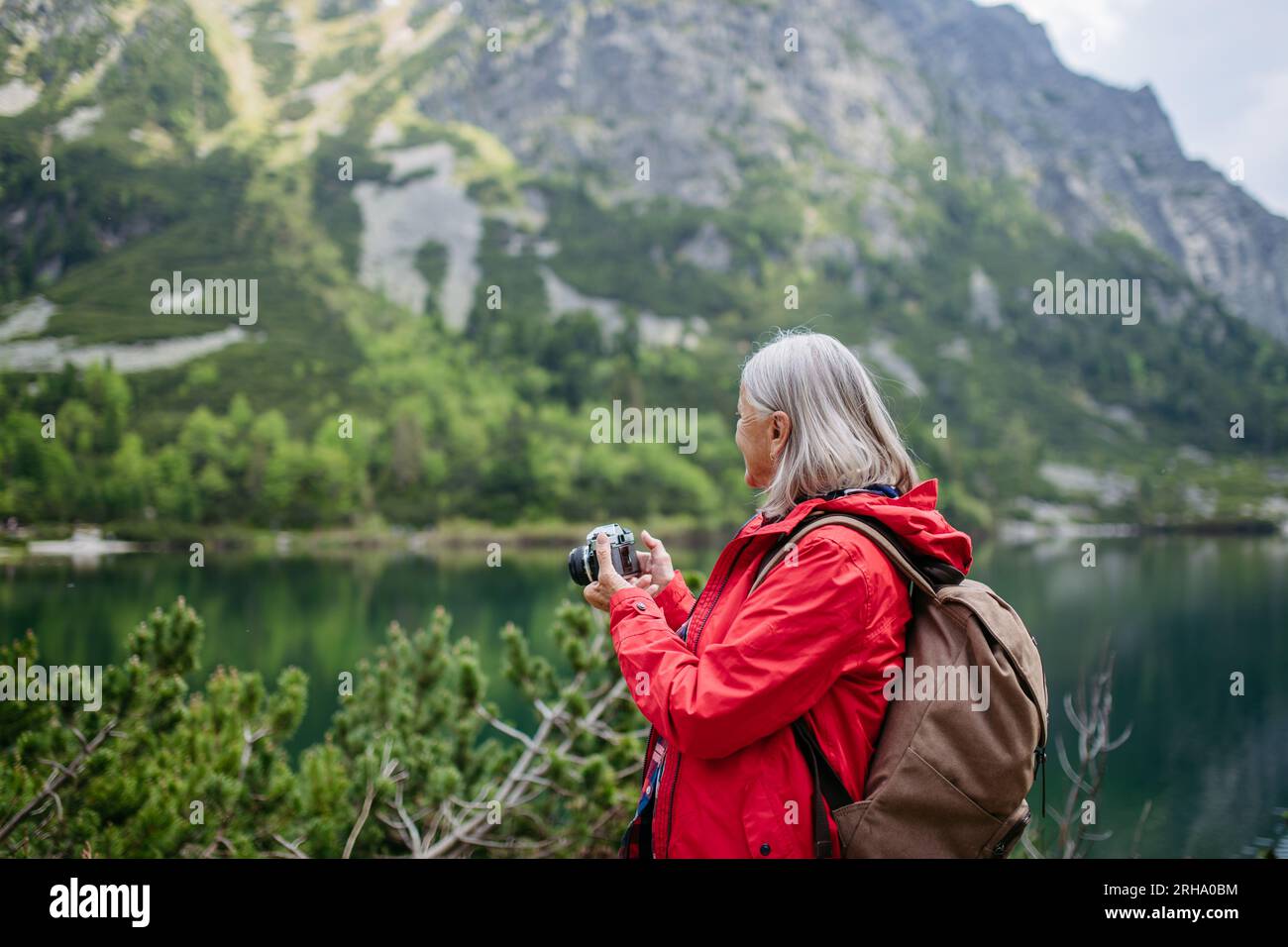Potrait de femme âgée active randonnant dans les montagnes d'automne. Banque D'Images