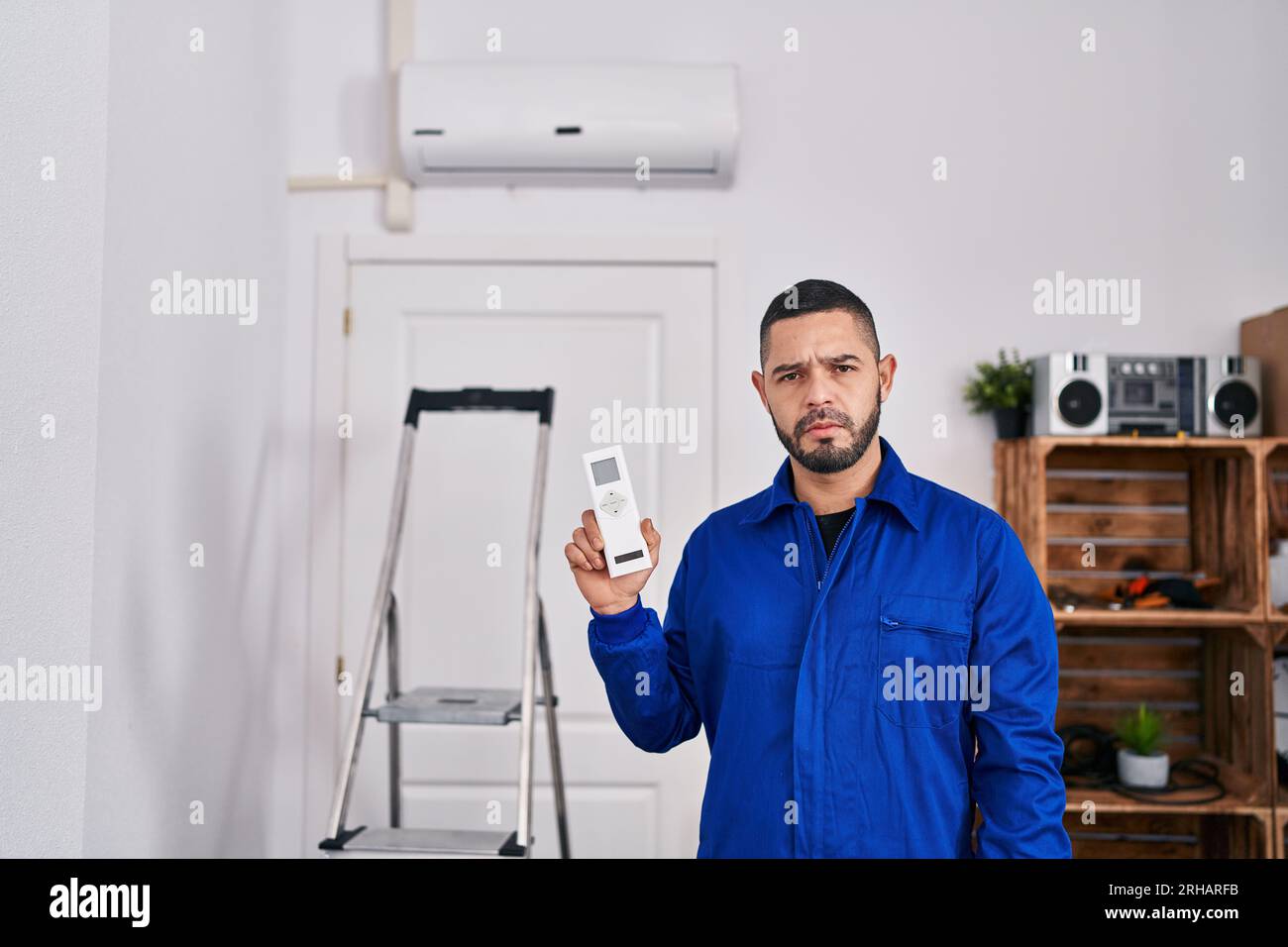 Réparateur hispanique travaillant avec l'attitude de pensée de climatiseur et l'expression sobre regardant sûr de soi Banque D'Images