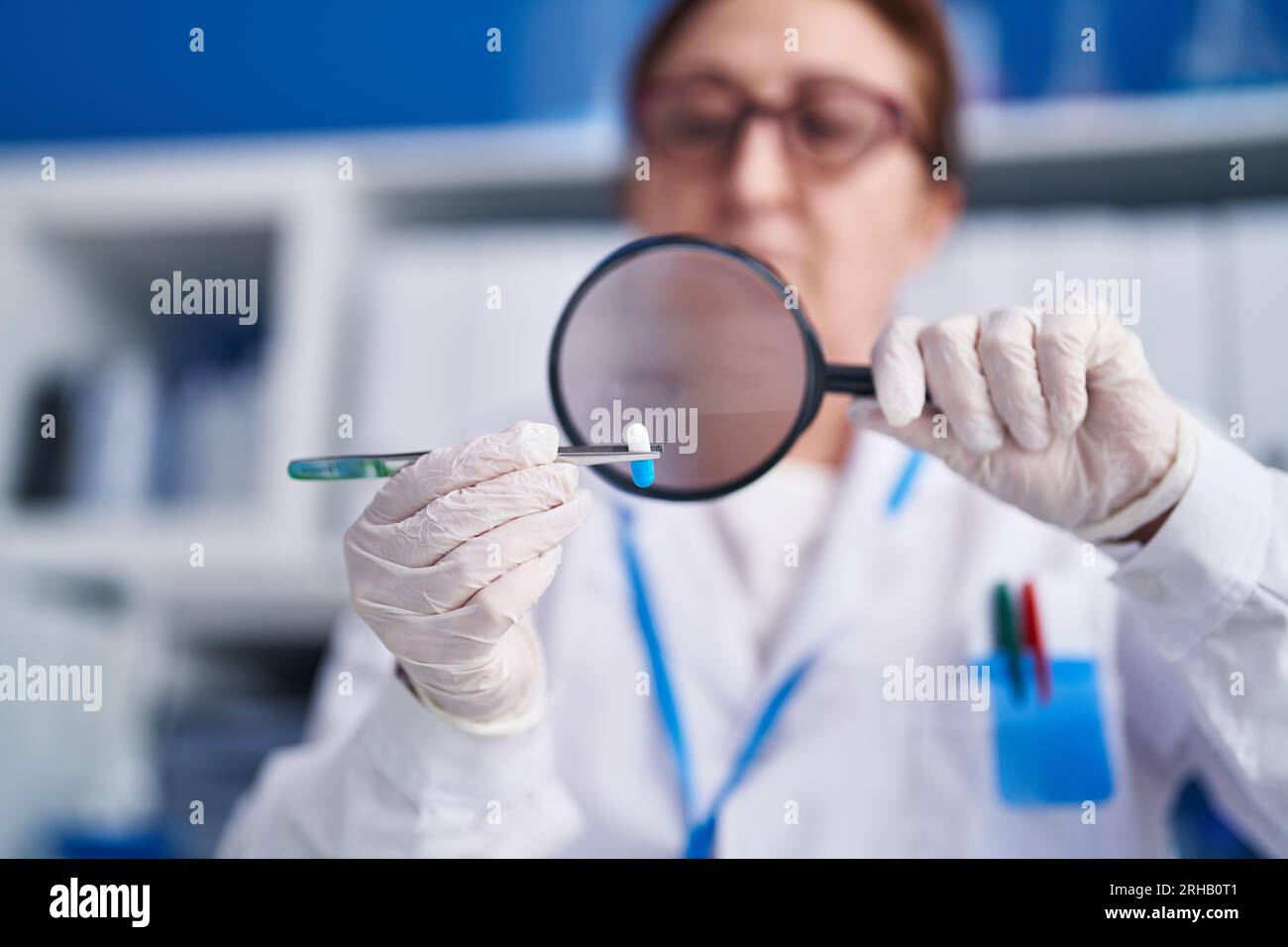 Femme scientifique senior utilisant la pilule de rétention de la loupe au  laboratoire Photo Stock - Alamy