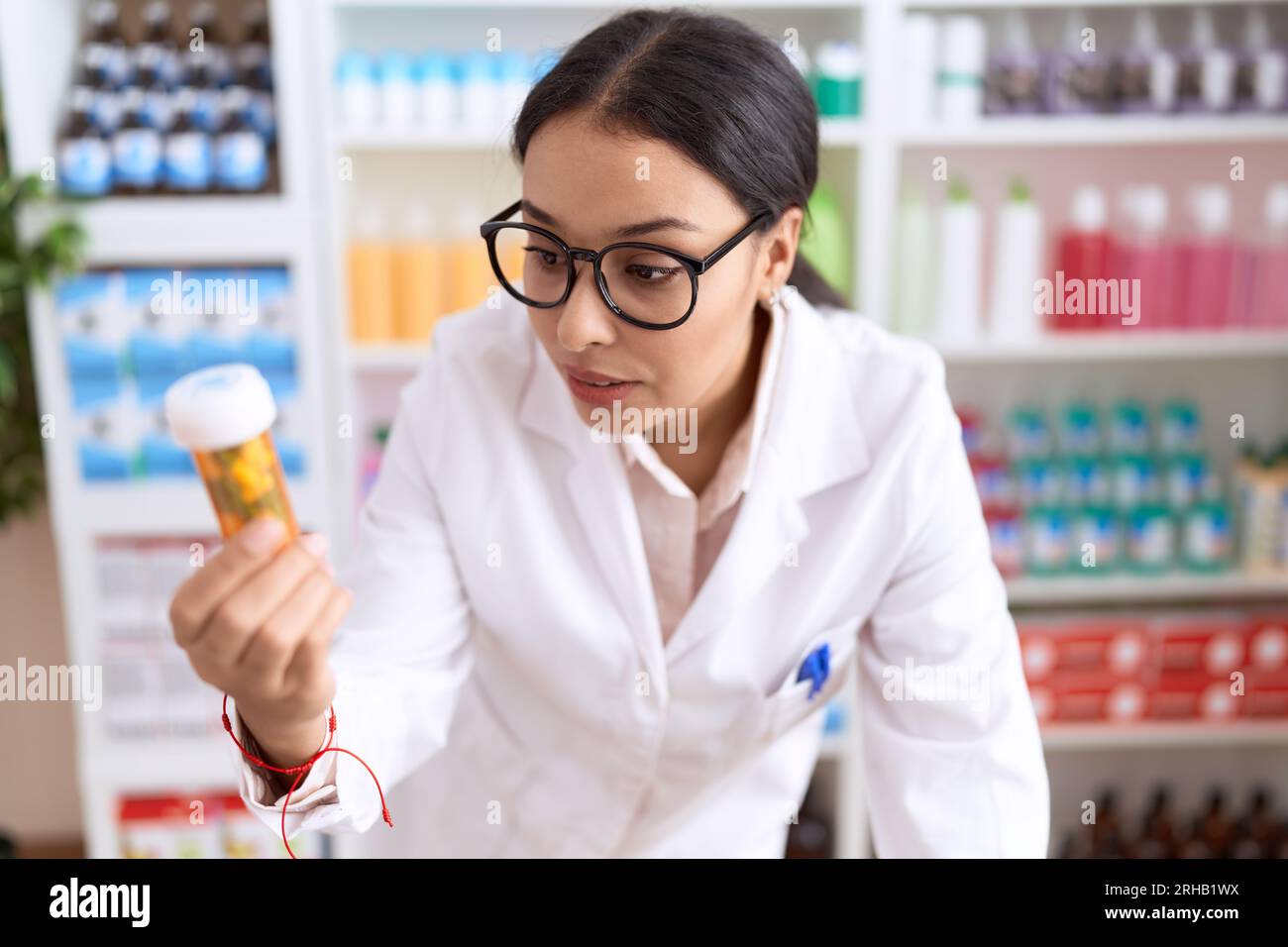 Jeune femme arabe pharmacien tenant le flacon de pilules à la pharmacie Banque D'Images