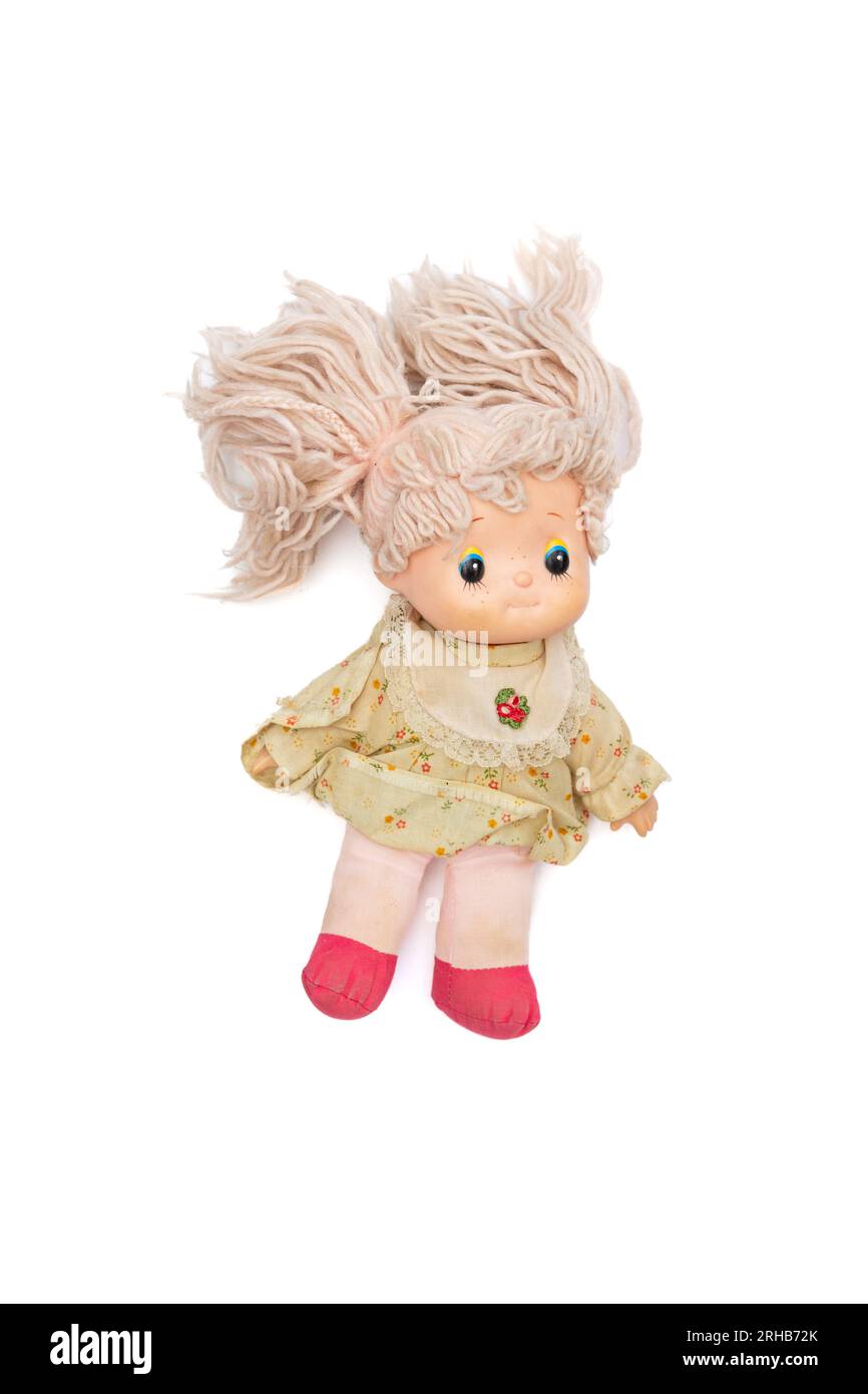 Jouet de poupée rose avec une tête en plastique, un corps doux et des cheveux de laine rose des années 1980, sur un fond blanc. Banque D'Images